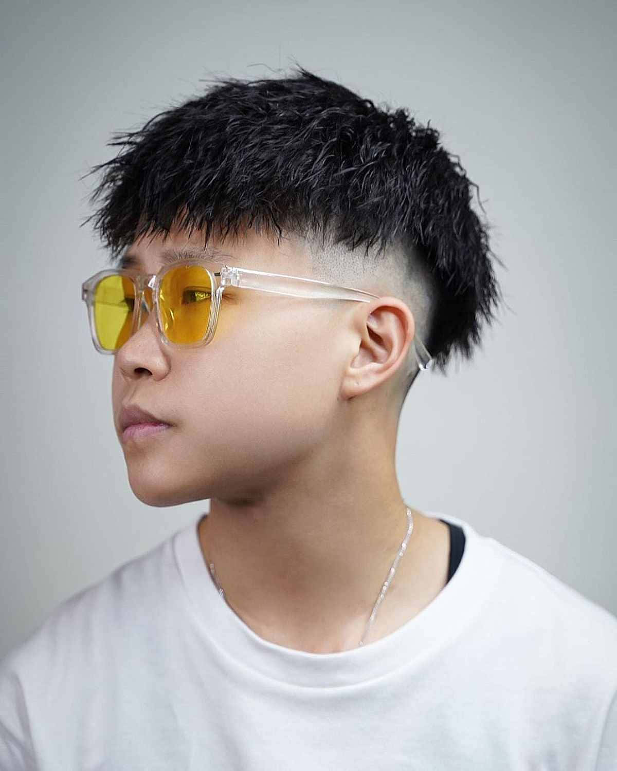 熱門青少年男模戴太陽眼鏡 壁紙 — 一位年輕男士留著質感漸層短髮，戴著大膽的黃色太陽眼鏡，背景是中性灰色。