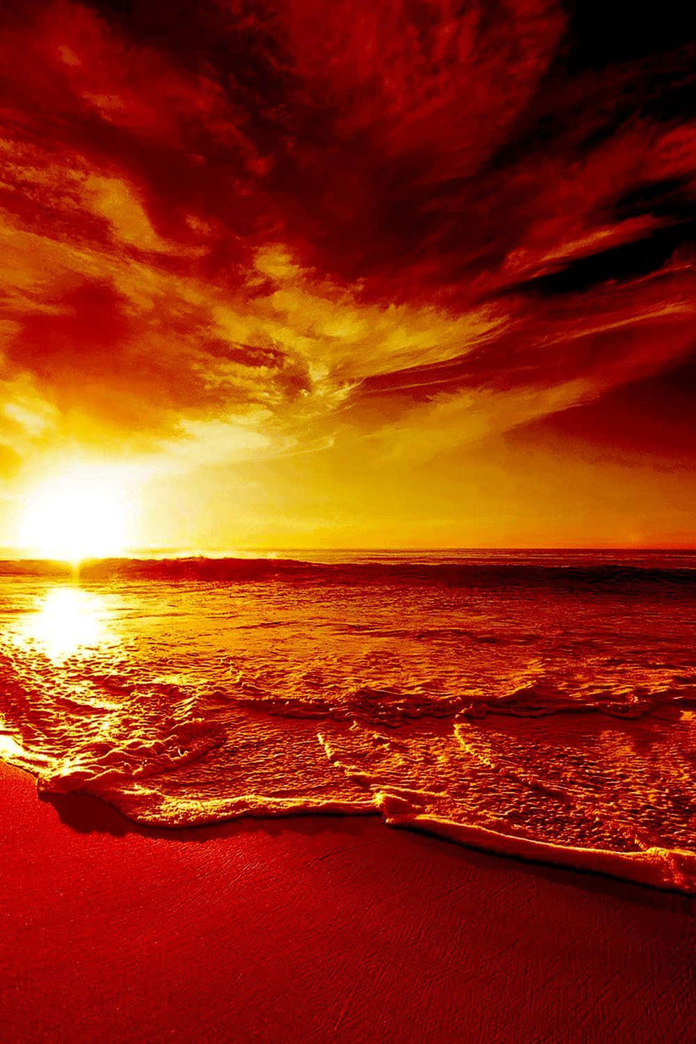 Yellow Beach 桌布 壁紙 — 熾熱的夕陽以強烈的紅色和金色描繪海洋和天空，海浪拍打著閃閃發光的沙灘。
