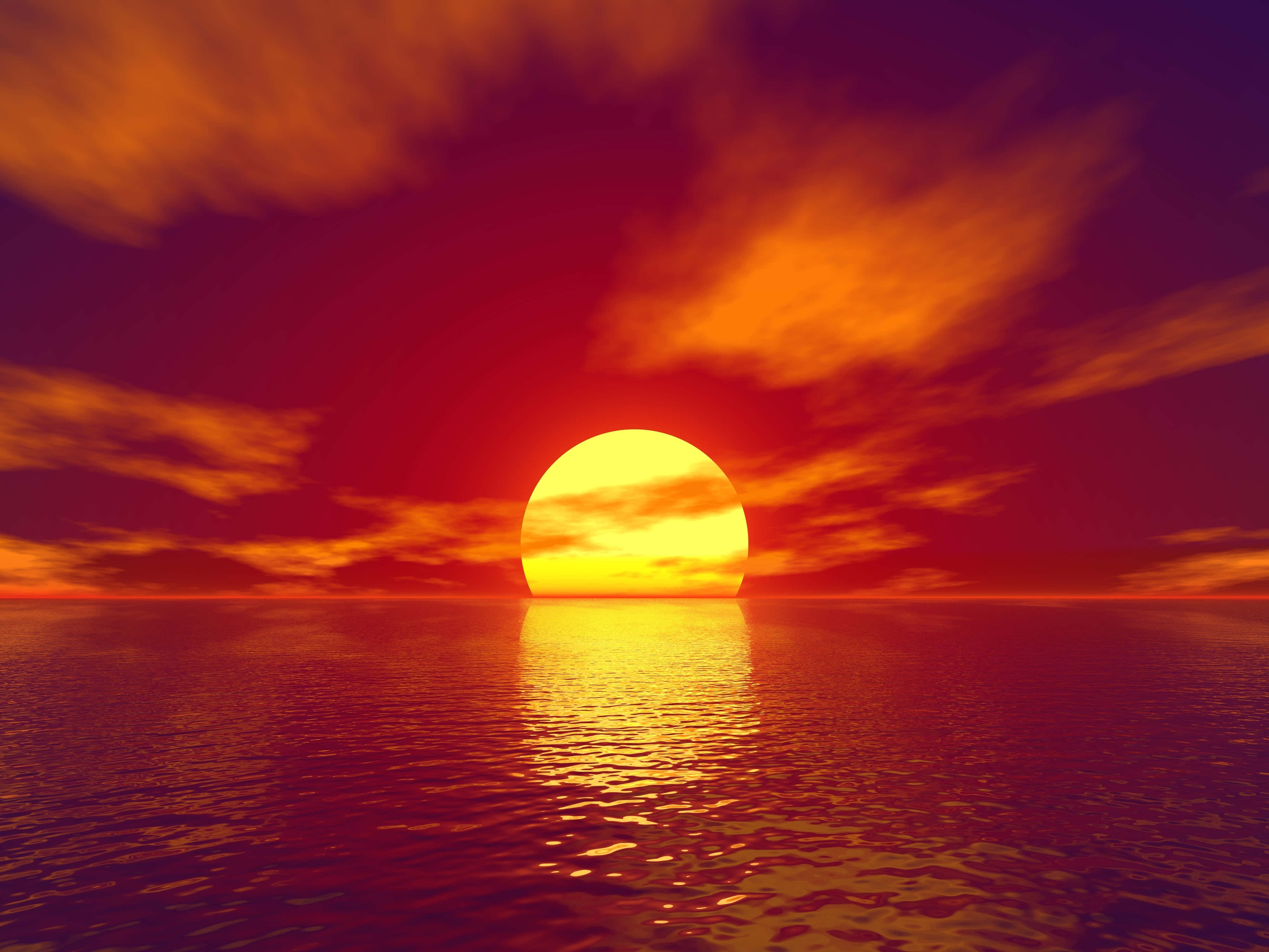 Sunset Ocean 桌布 壁紙 — 熾熱的太陽在平靜的海洋上落下，在天空和水面上投射出鮮豔的橙色和紅色色調。