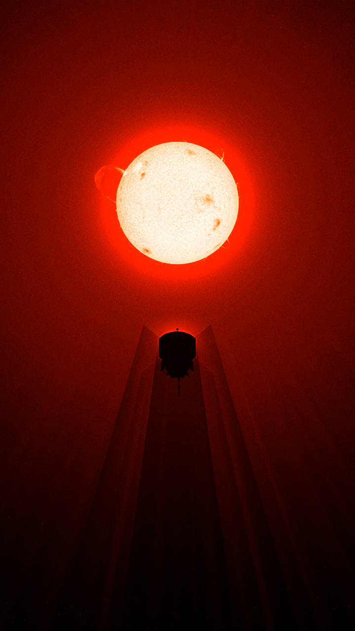 熾熱閃耀太陽驚豔手機壁紙 壁紙 — 一個帶有可見太陽日珥的火紅太陽，在太空望遠鏡的剪影上方發光。