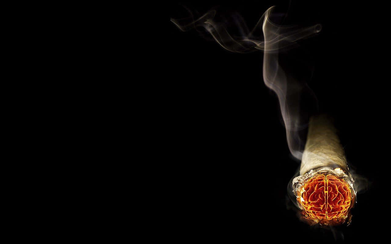 燃燒中的煙草捲煙 壁紙 — 一支已點燃的大麻煙，帶有發光的橙色餘燼和繚繞的煙霧，襯以純黑色背景。