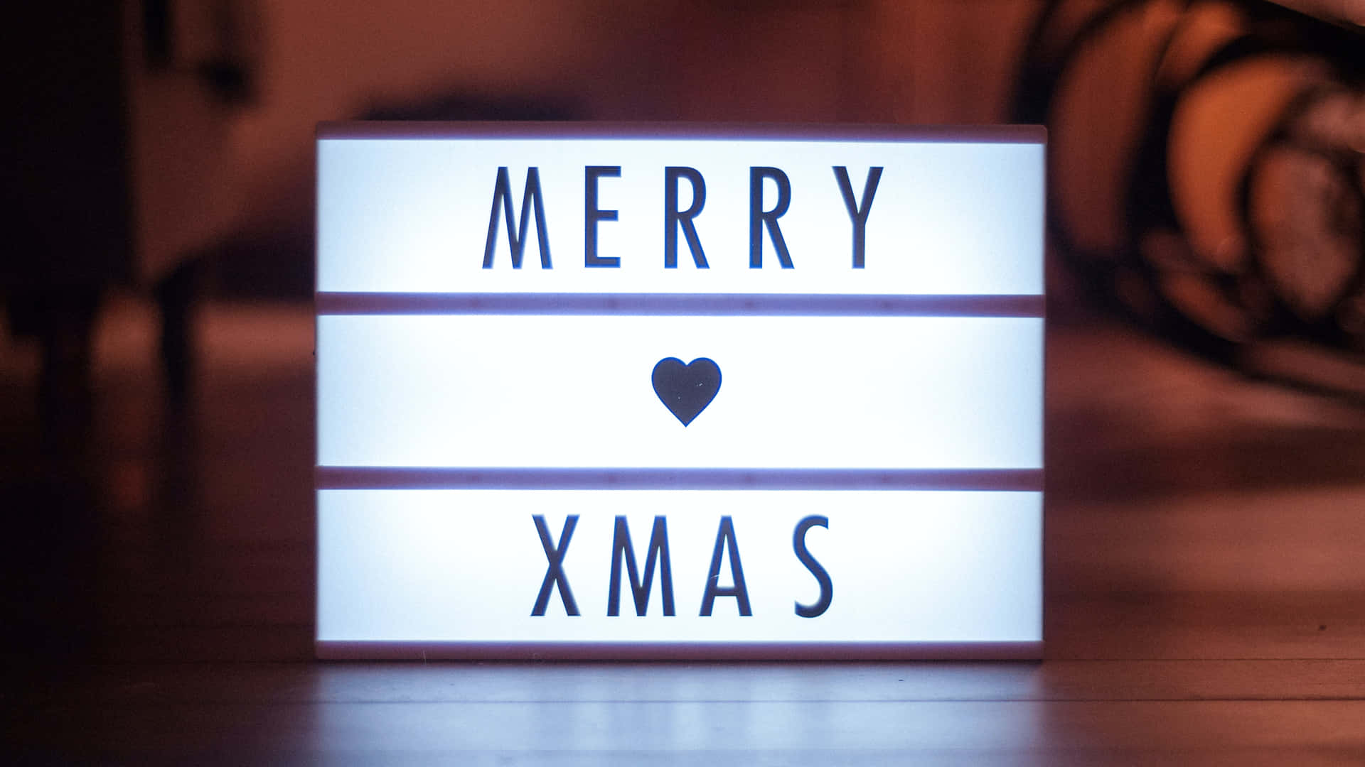 一個發光的燈箱，帶有「MERRY XMAS」和心形符號，營造節日氣氛。