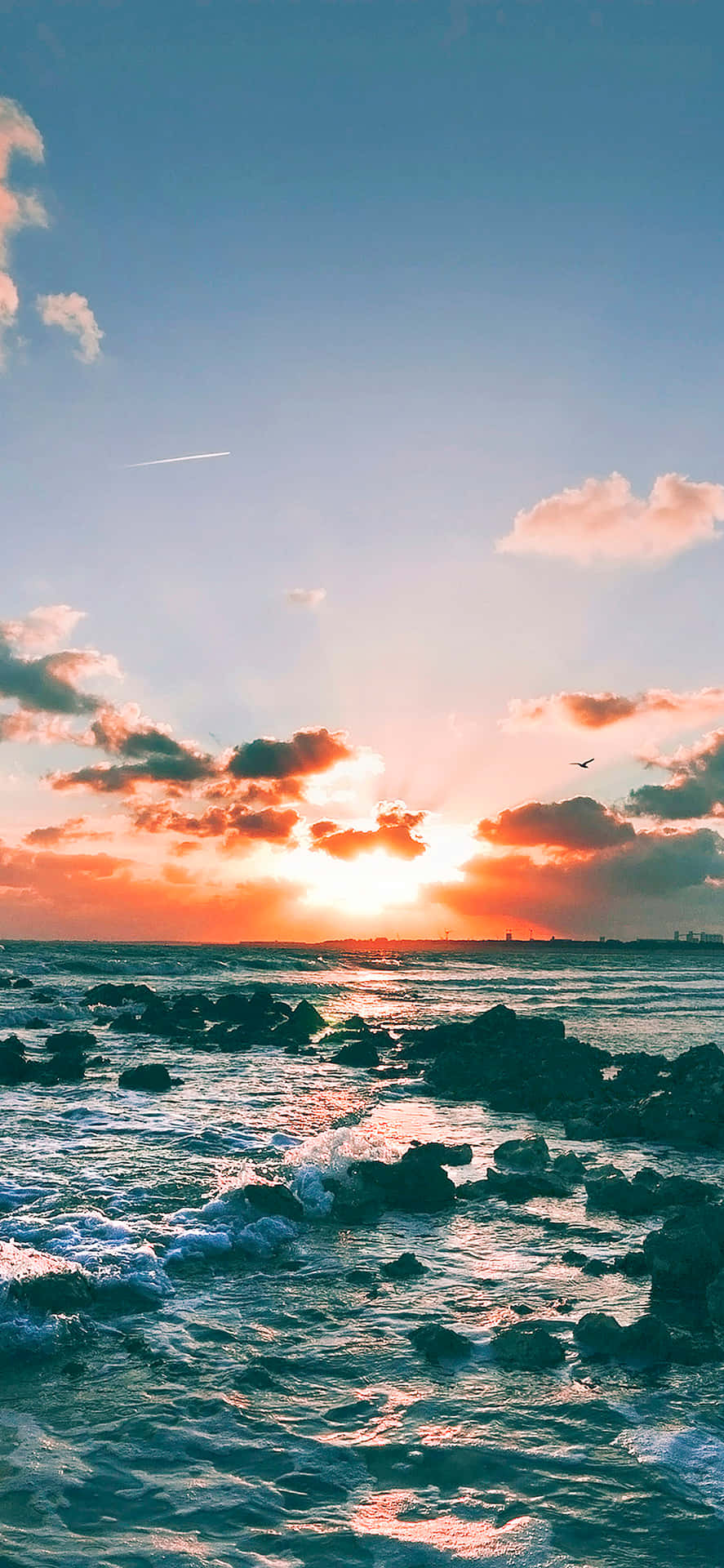 海洋上的夕陽，海浪拍打岩石