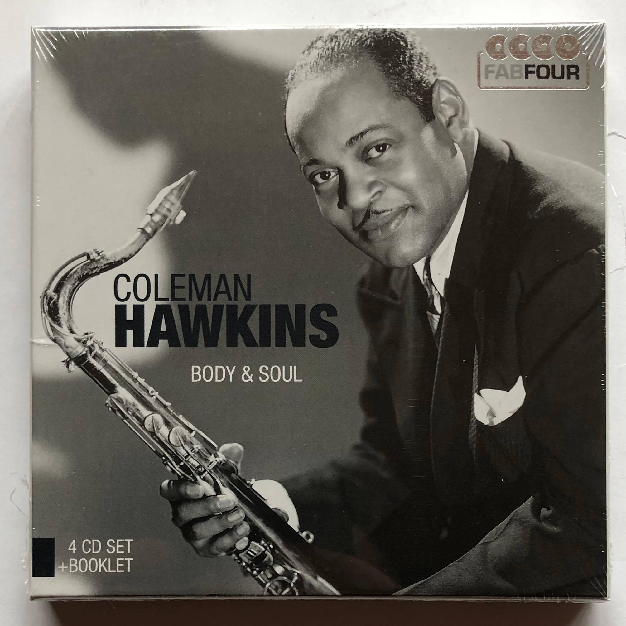 爵士傳奇柯爾曼·霍金斯《Body & Soul》專輯封面 壁紙 — 爵士傳奇Coleman Hawkins微笑著手持色士風的黑白肖像，背景柔和模糊。