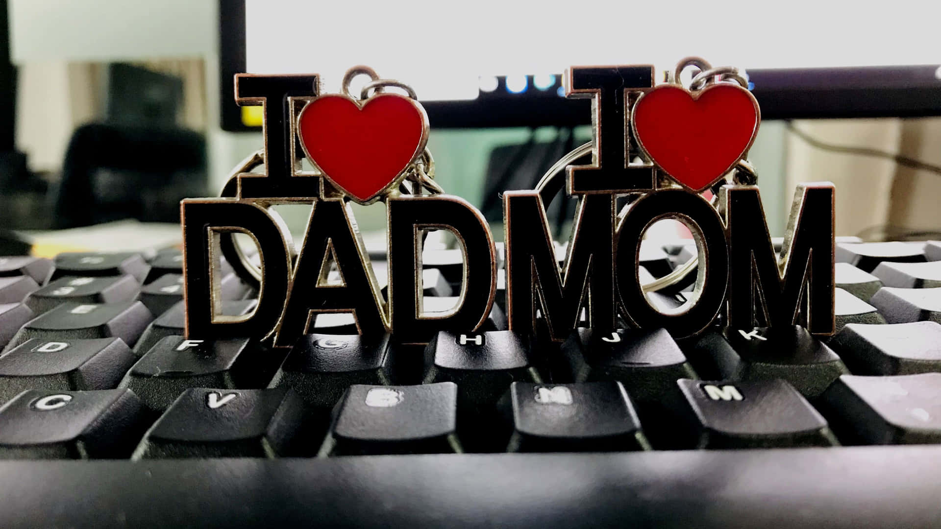 電腦鍵盤上的兩個 I heart DAD 和 I heart MOM 鑰匙扣。