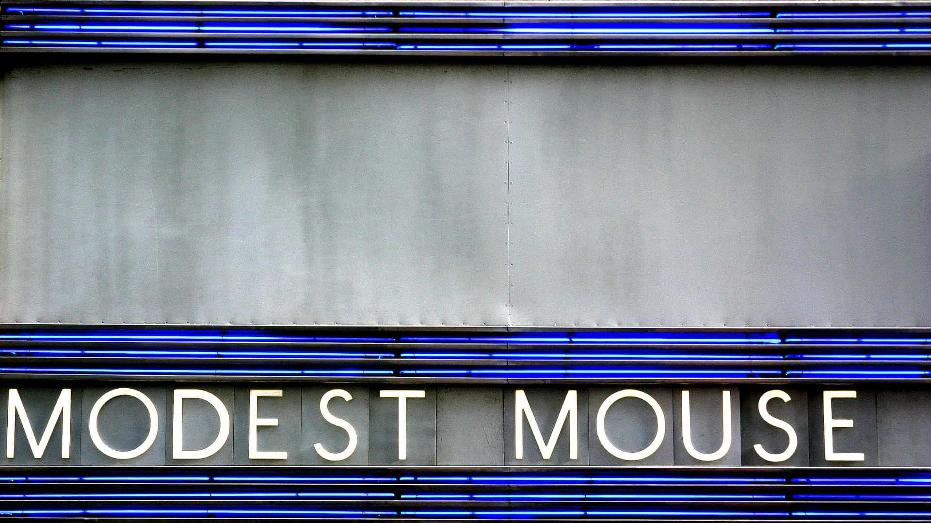 夜晚灰色建築物外牆上的 Modest Mouse 霓虹燈牌。