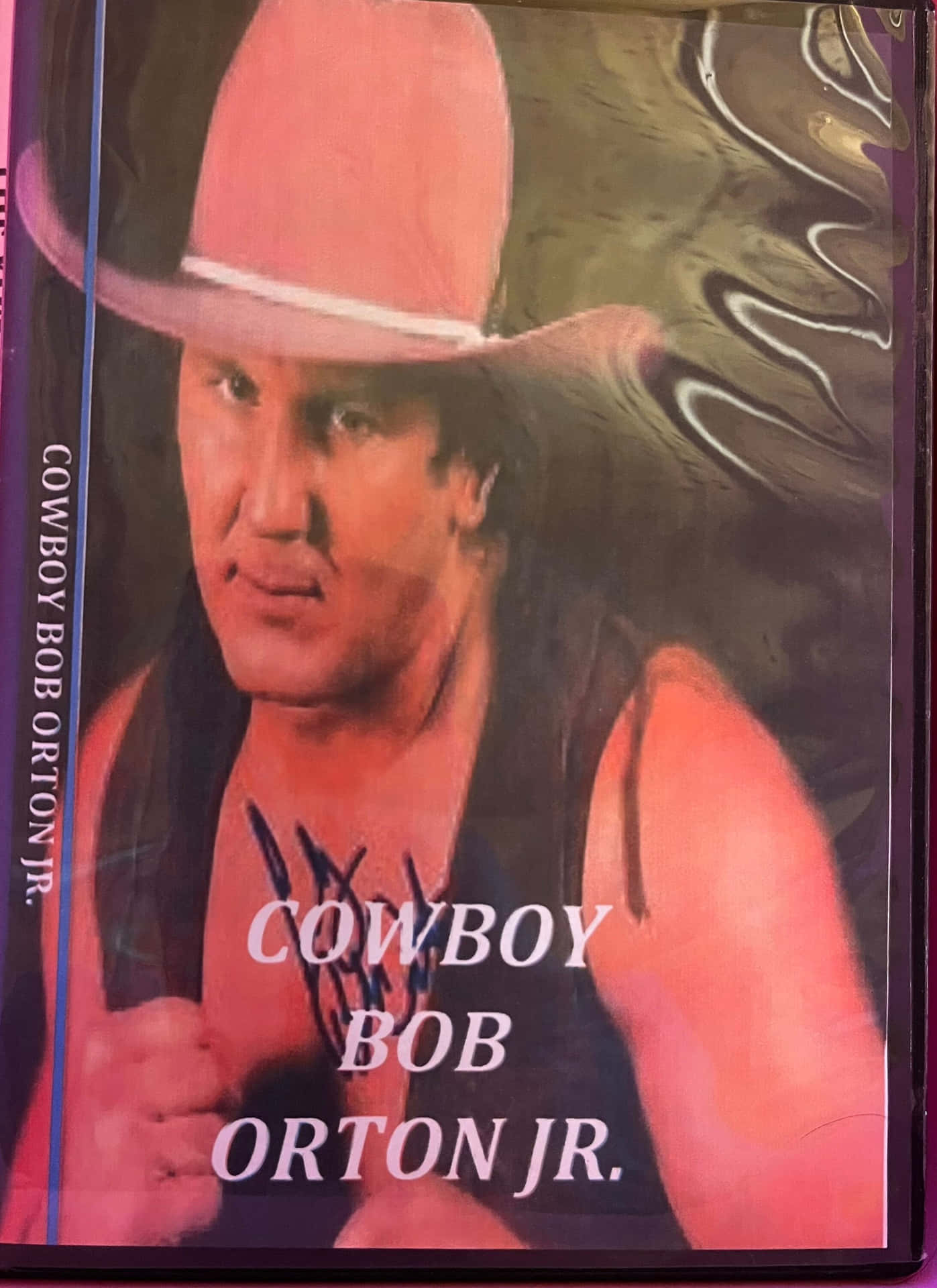 摔角手牛仔Bob Orton Jr.戴粉紅色帽子，附有簽名和粗體文字。