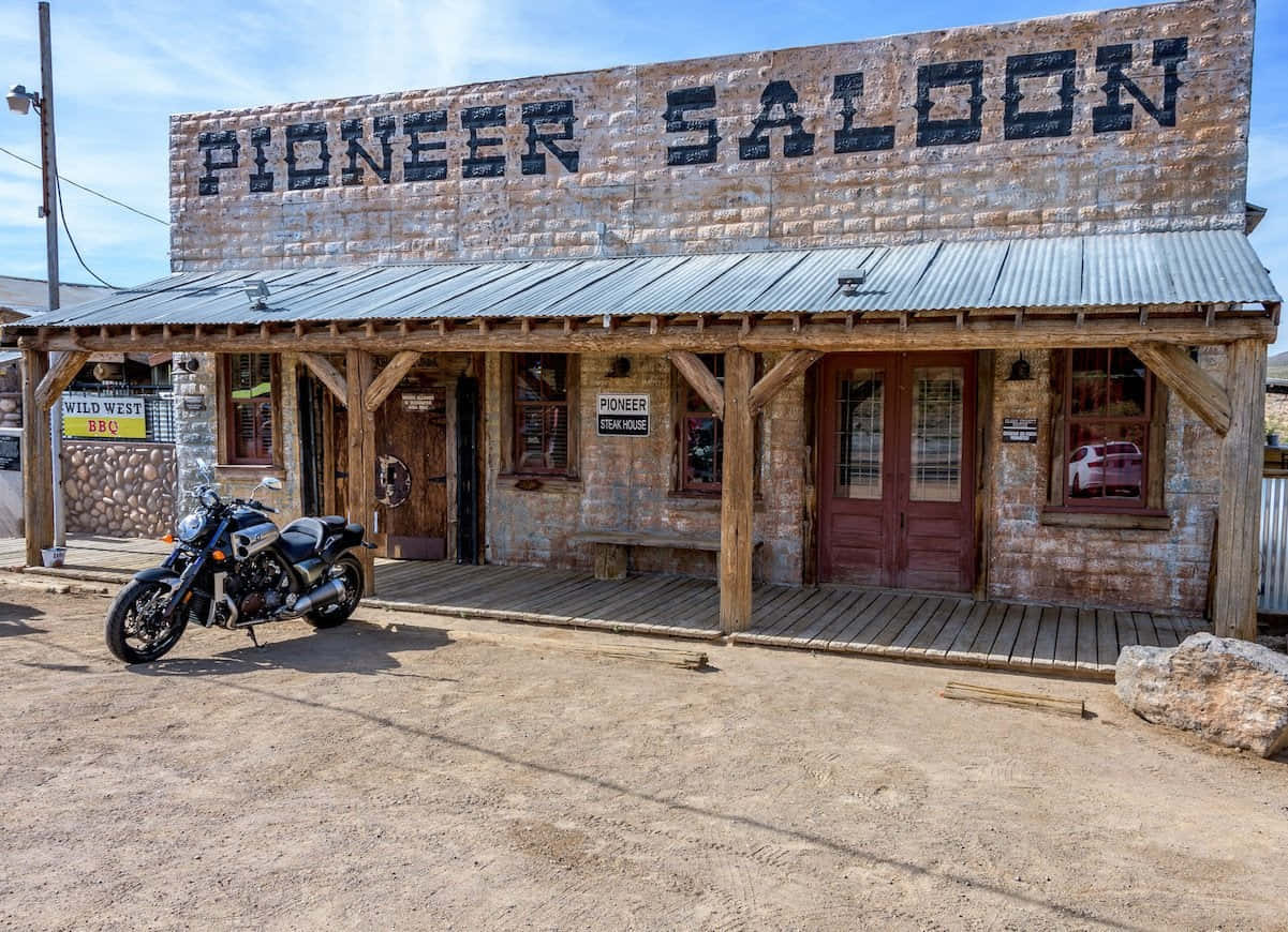 電單車停泊在沙漠環境中的 Pioneer Saloon 前。