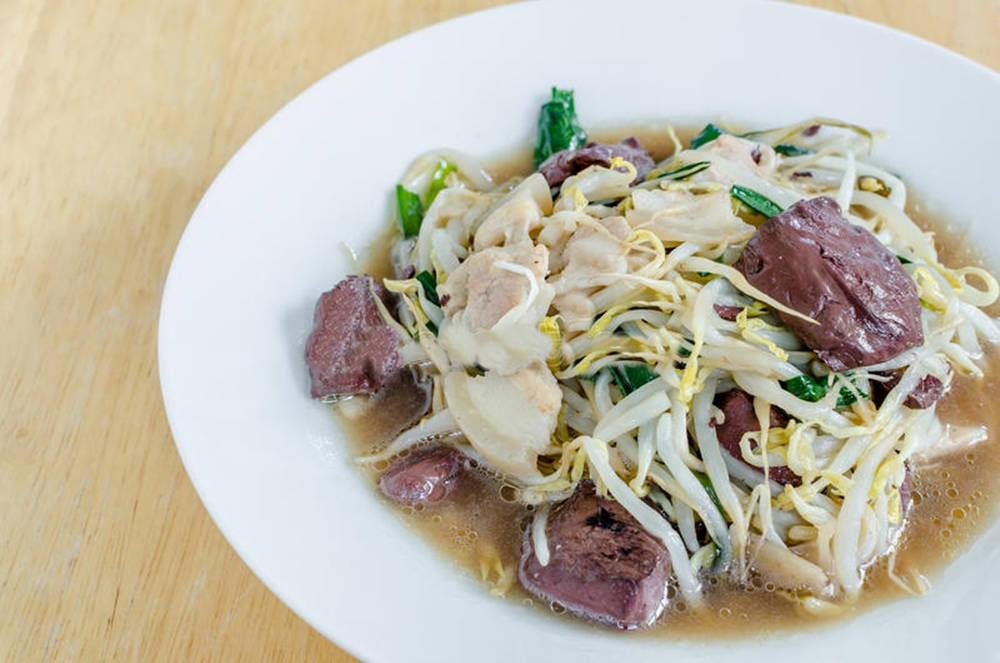 冒煙的碗，豆芽炒菜配雞肉和牛肉，放在木桌上