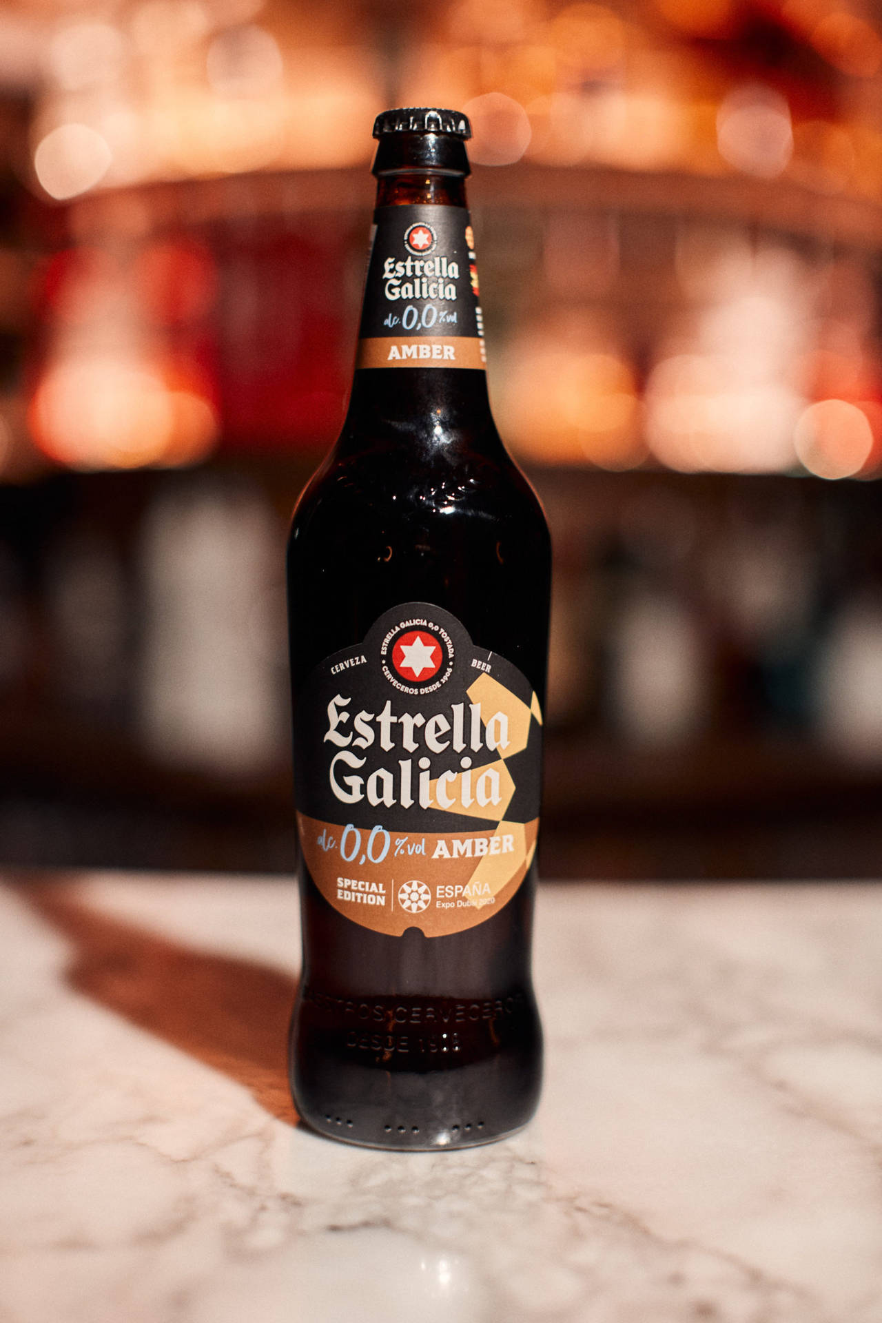 Estrella Galicia 0.0無酒精琥珀色啤酒瓶放在大理石吧檯上。