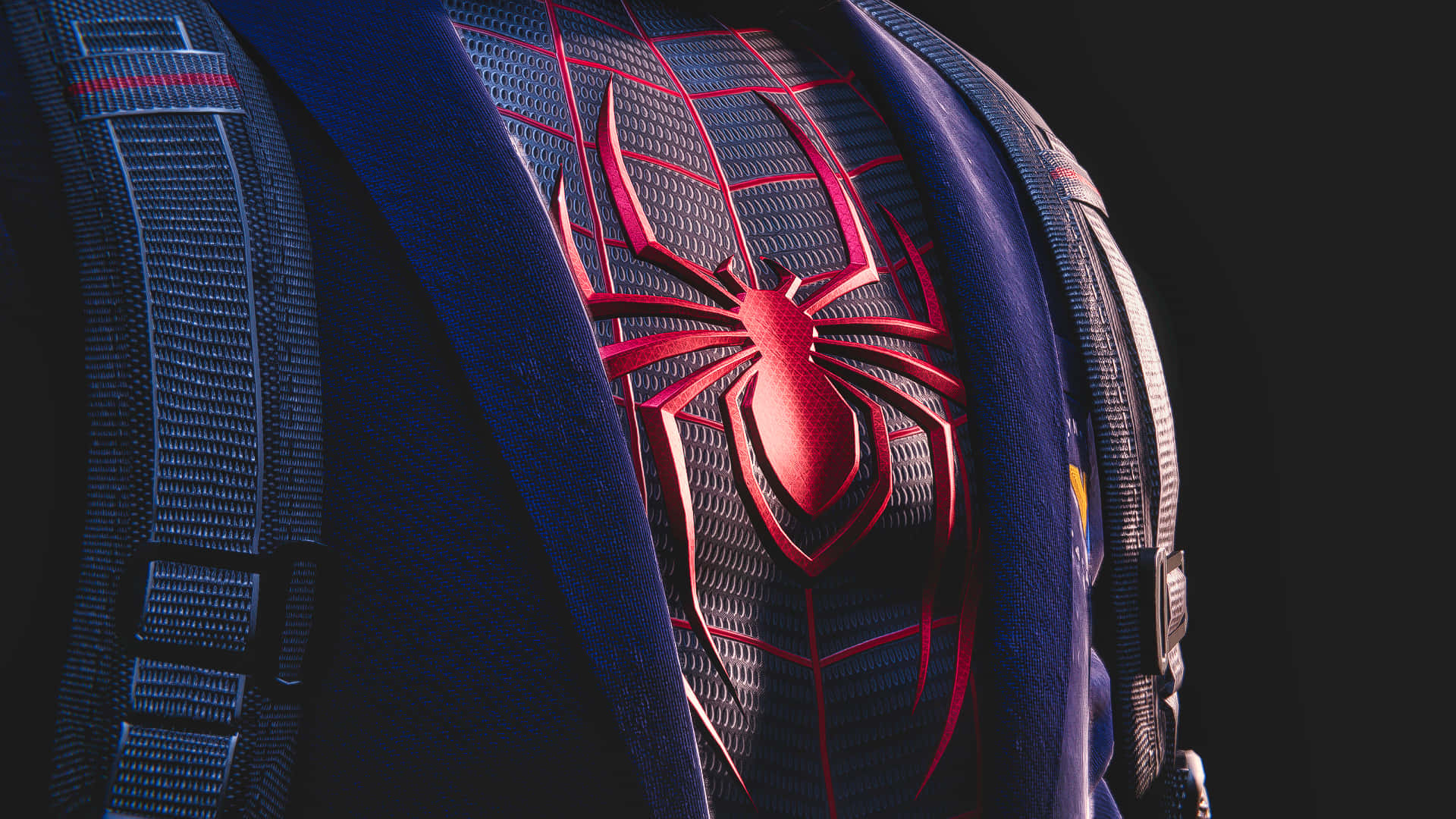Miles Morales 動漫 桌布 壁紙 — 特寫：帶有紋理的藍色和紅色蜘蛛俠戰衣，在深色背景上帶有發光的紅色蜘蛛標誌。