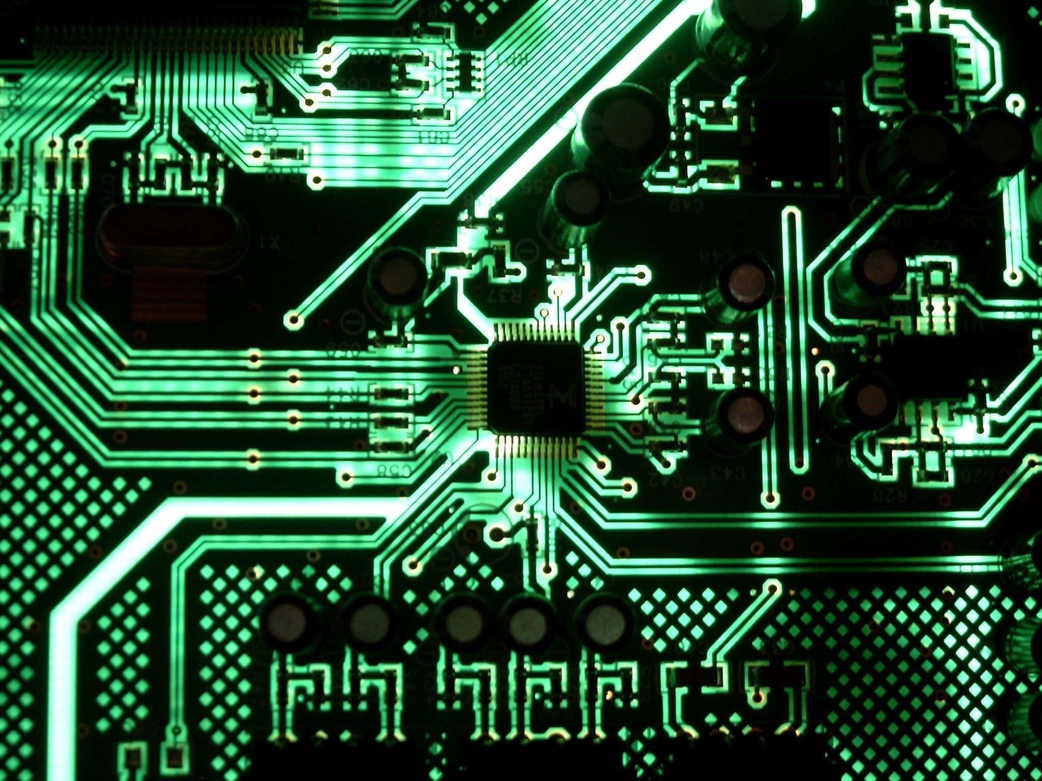 Electronics 桌布 壁紙 — 特寫一個發光的綠色電路板，帶有複雜的線路和一個中央芯片，在黑暗背景下被照亮。