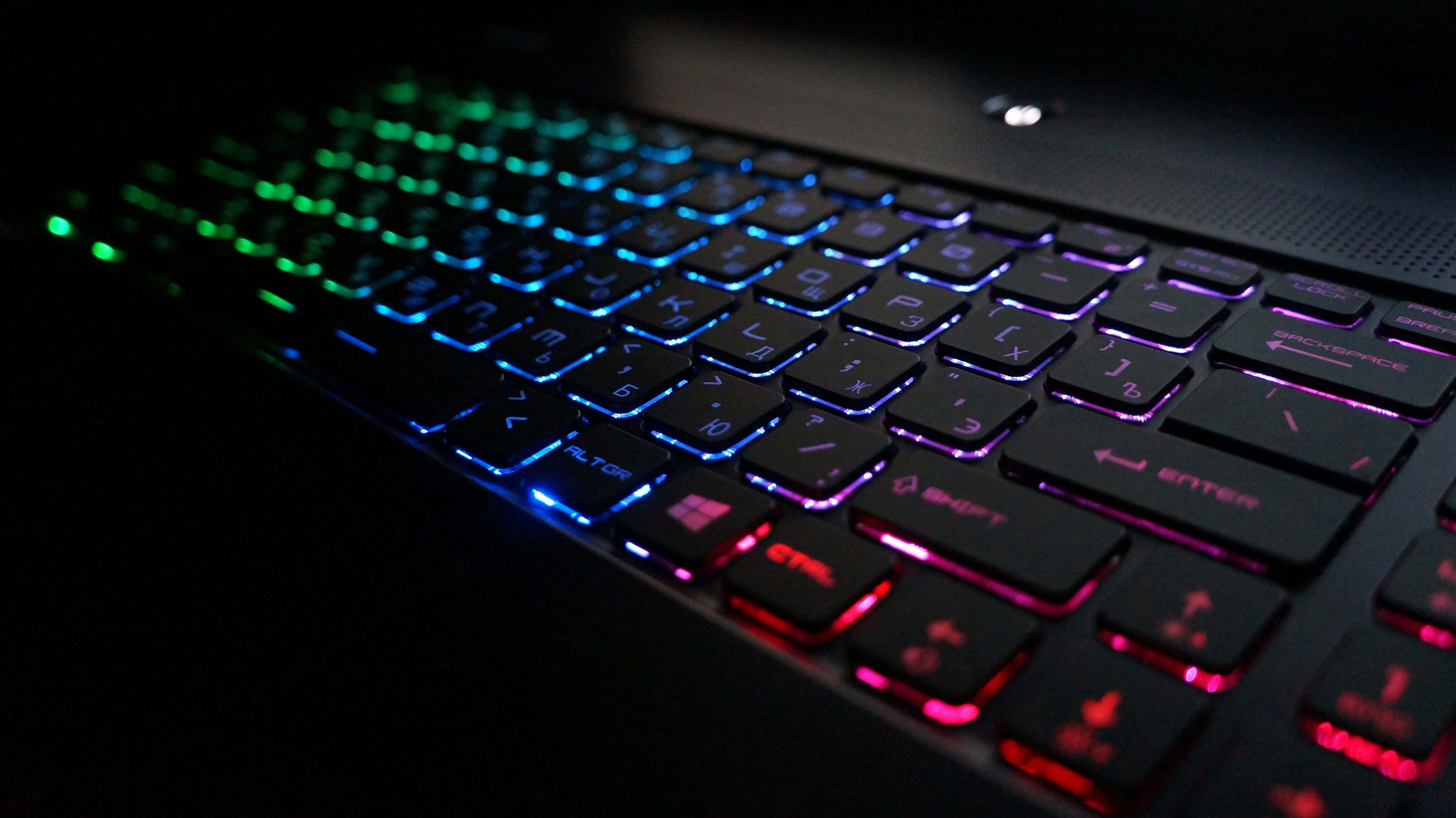 Gaming Keyboards 桌布 壁紙 — 特寫一個遊戲鍵盤，帶有鮮豔的彩虹背光，在黑暗背景下發光。