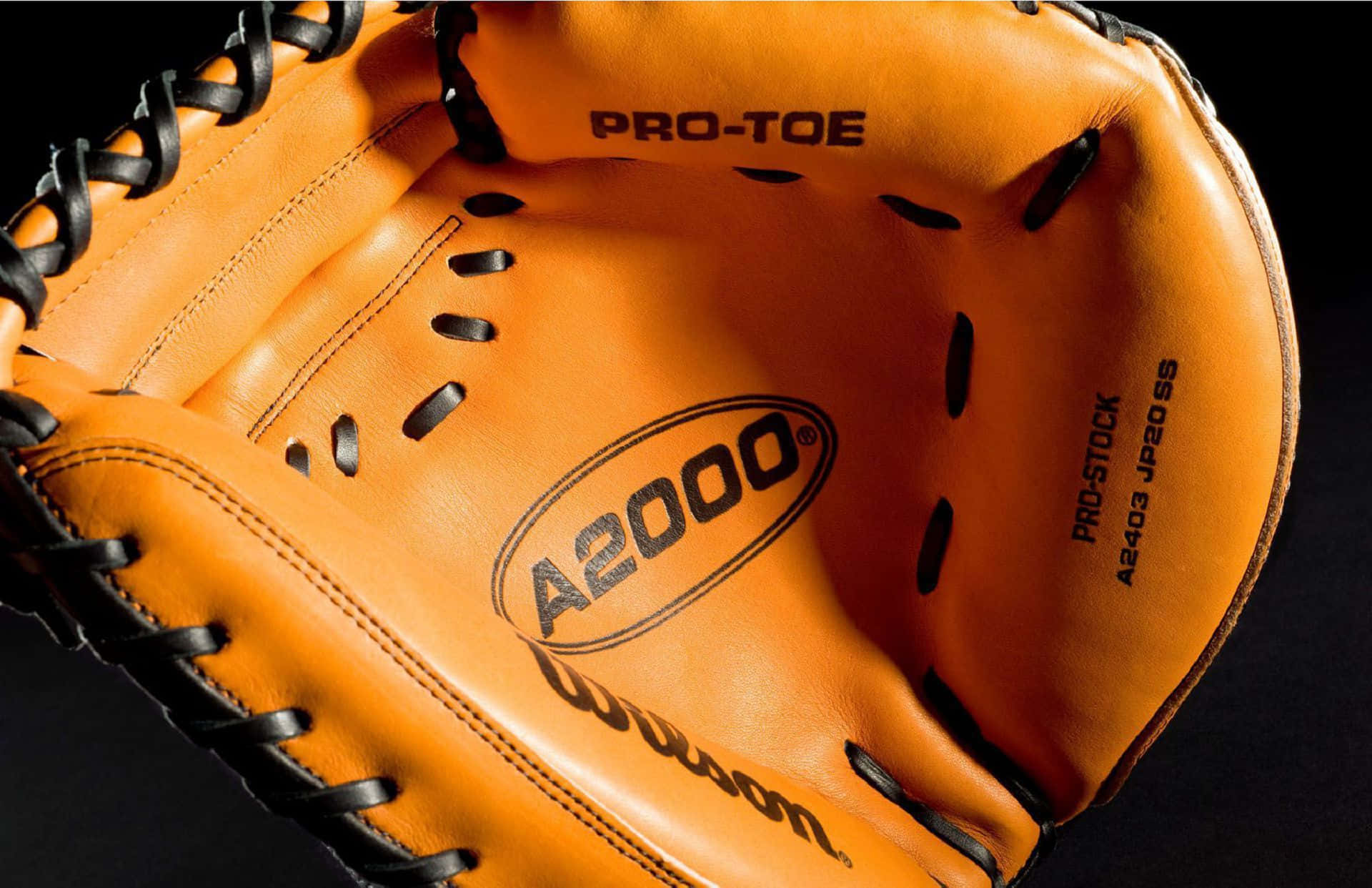 Baseball Gloves 桌布 壁紙 — 特寫一個鮮橙色棒球捕手手套，帶有黑色綁帶和 'A2000' 標誌，背景為深色。