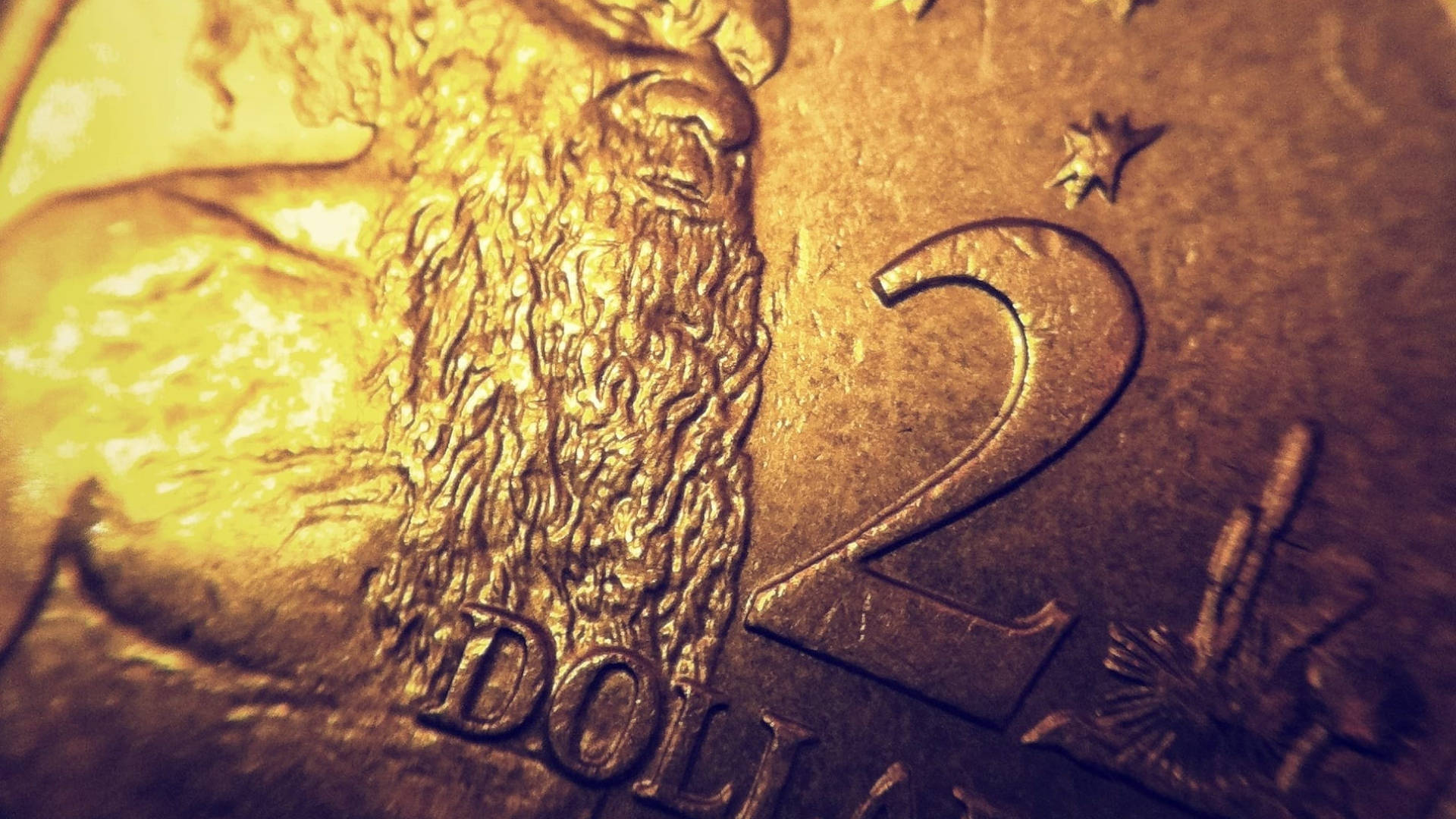 錢 桌布 壁紙 — 特寫一枚金色兩美元硬幣，在溫暖燈光下顯示細緻的鬍鬚紋理和浮雕數字。