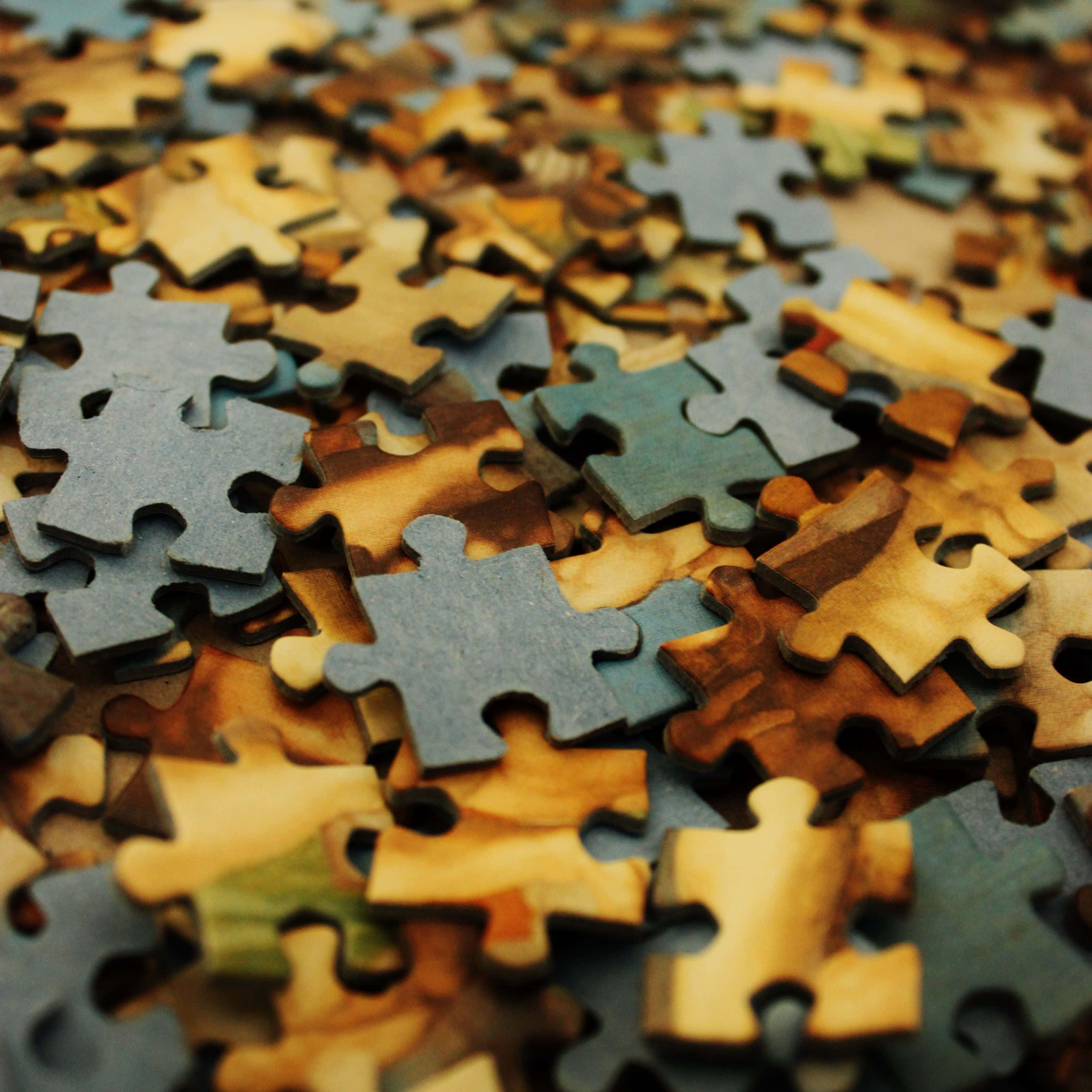 Puzzle Games 桌布 壁紙 — 特寫散落的拼圖碎片，大地色調，淺景深。