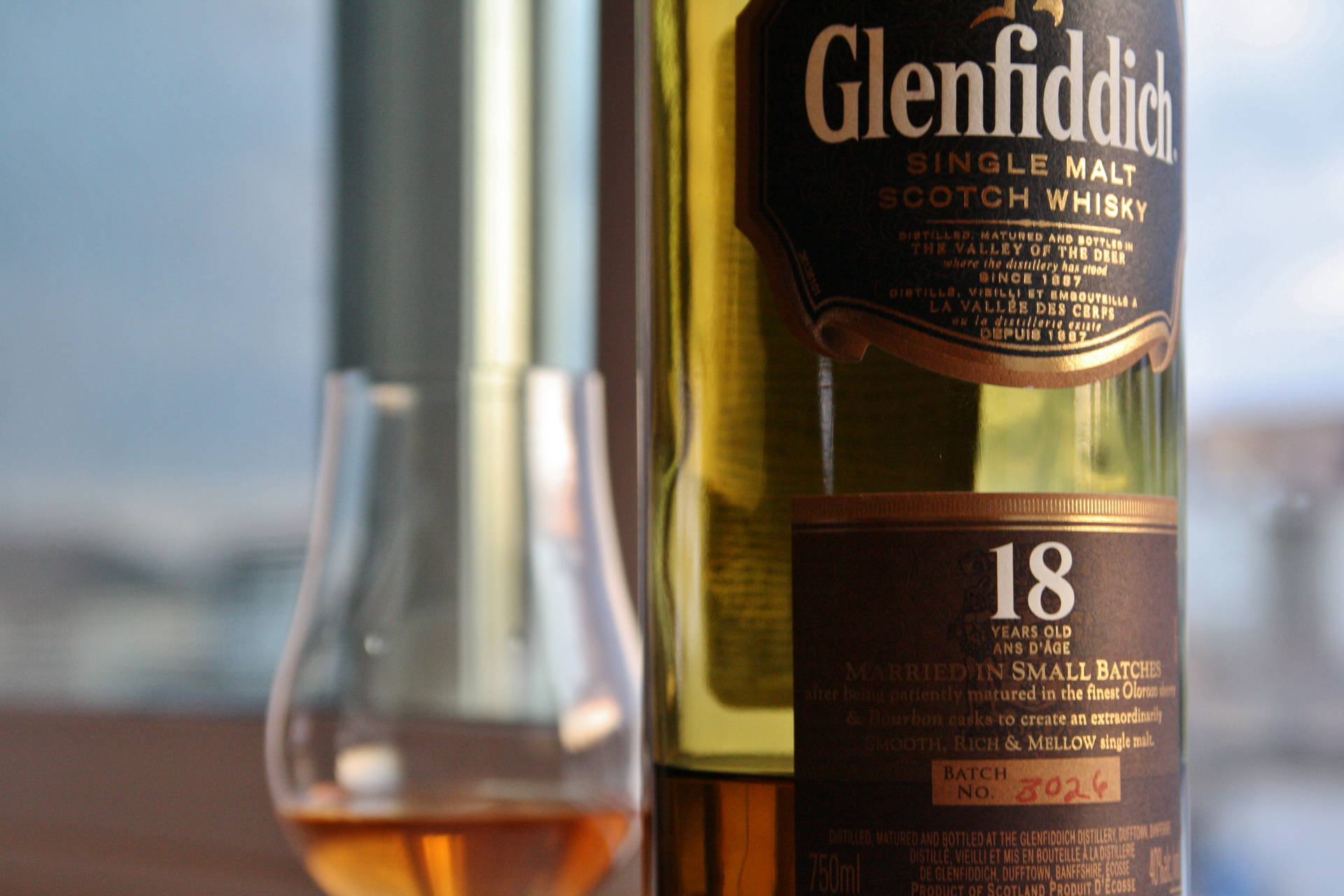 Glenfiddich 18年威士忌酒瓶與裝滿琥珀色液體的品酒杯。