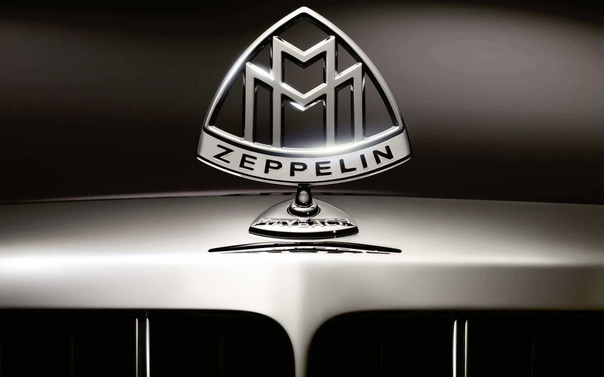 Car Logo 桌布 壁紙 — 特寫鏡頭，一個閃亮的銀色 Zeppelin 徽章安裝在豪華汽車的引擎蓋上，背景為深色。