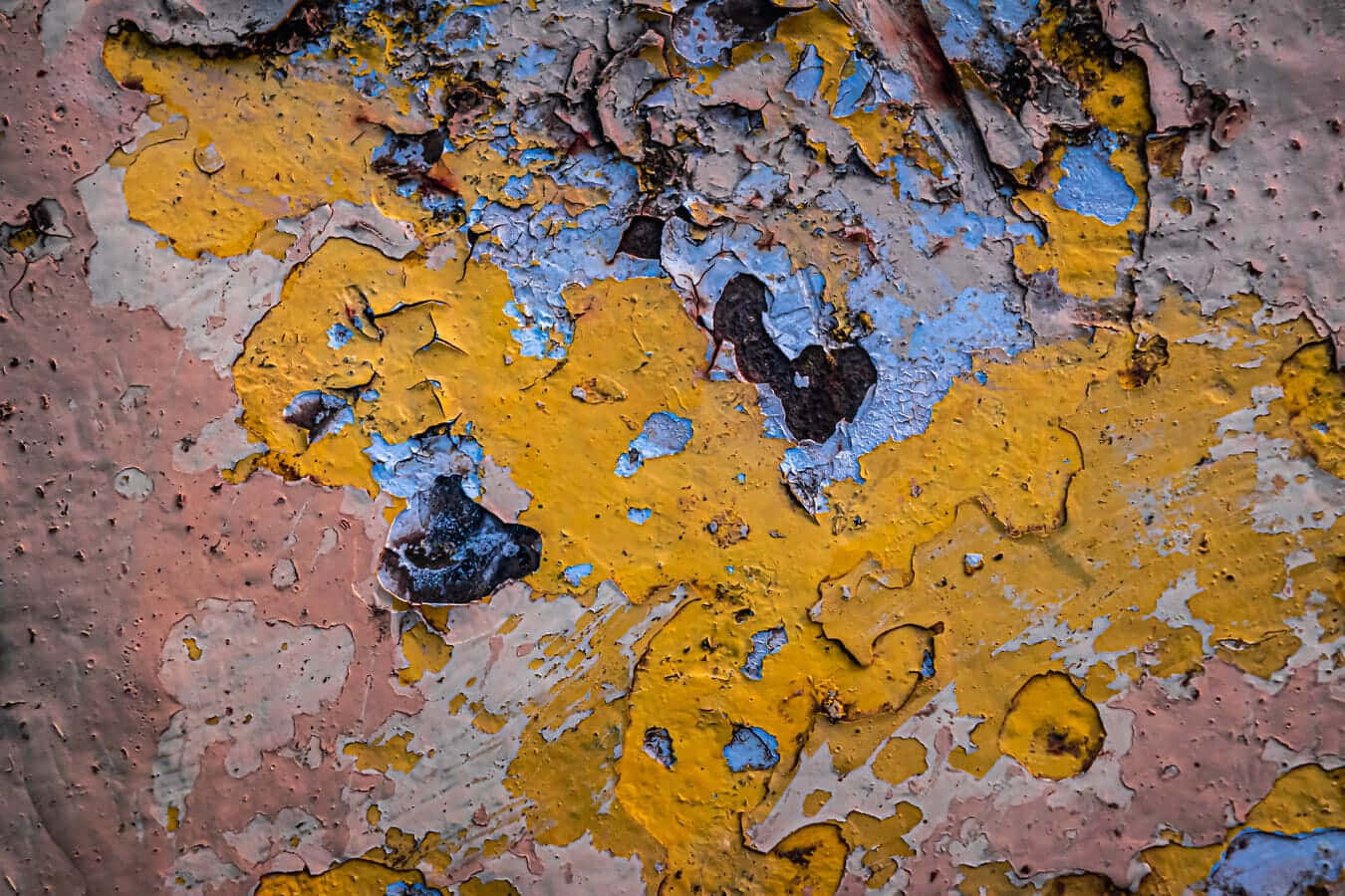 Paint Texture 桌布 壁紙 — 特寫鏡頭，呈現風化油漆剝落，露出鮮豔的黃色、藍色和粉紅色，以及下方紋理分明的層次。