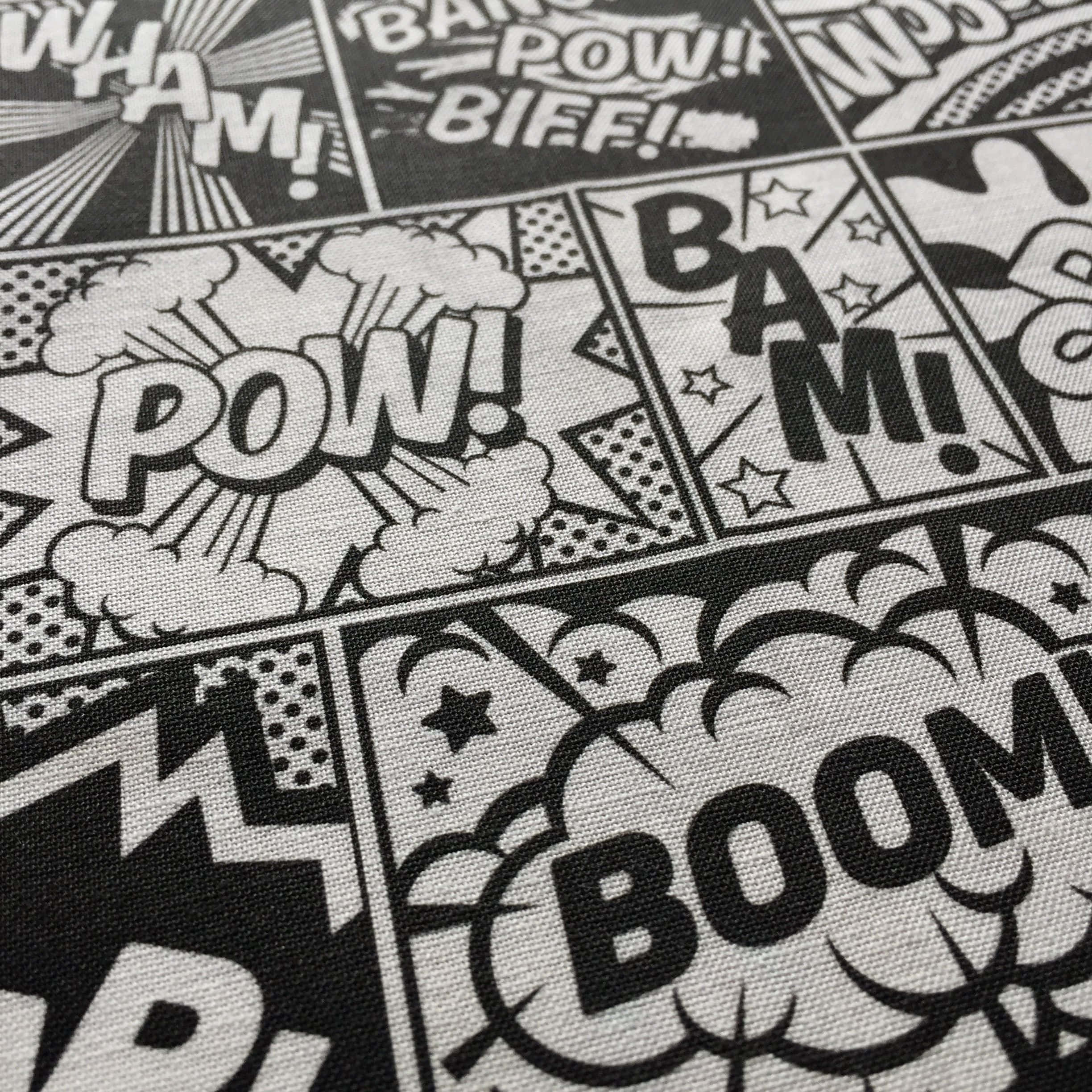 Black And White Comic 桌布 壁紙 — 特寫鏡頭，在紋理布料上呈現大膽的黑白漫畫書音效，如 POW、BAM 和 BOOM。