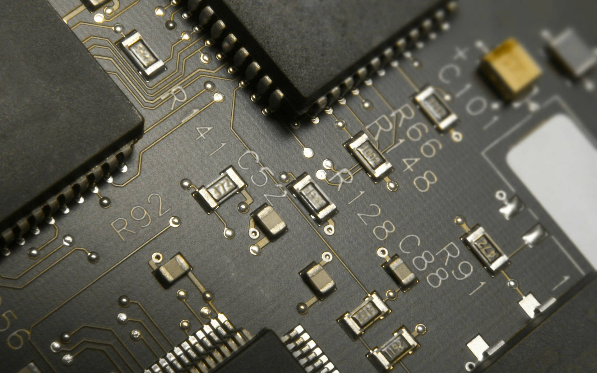特寫鏡頭：電路板，帶有電子元件和金色走線。 — 電路板 GIF 壁紙
