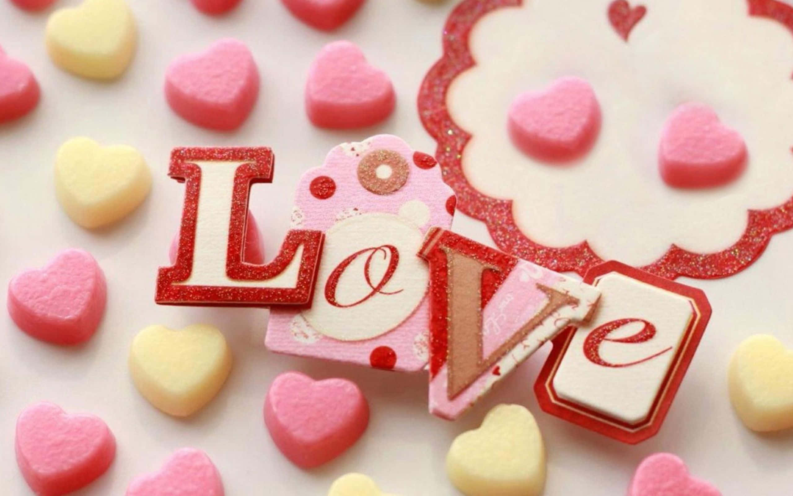 Sweet 桌布 壁紙 — 特寫鏡頭，顯示以閃亮紅色字母拼出的「Love」一詞，周圍環繞著粉紅色和黃色的心形糖果。