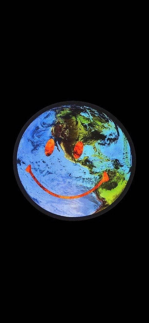 微笑的地球行星，帶有橙色眼睛和嘴巴，在黑色太空背景下。