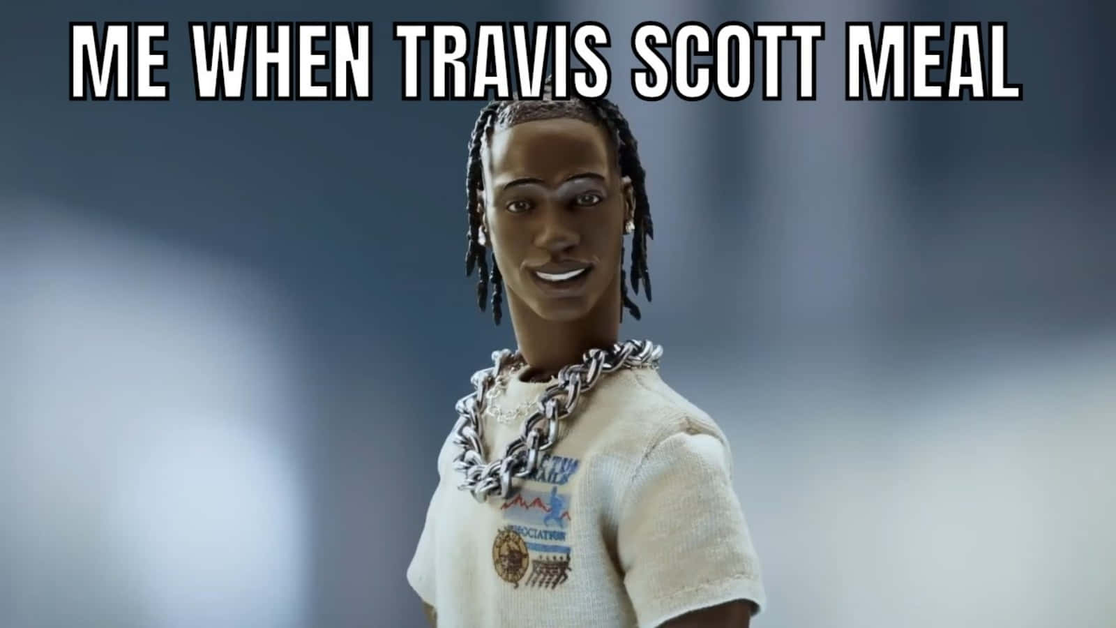 特拉維斯·斯科特做出搞怪表情 壁紙 — 一個微笑的Travis Scott動作人偶，穿著白色T恤和粗鏈條，背景為模糊的灰色。