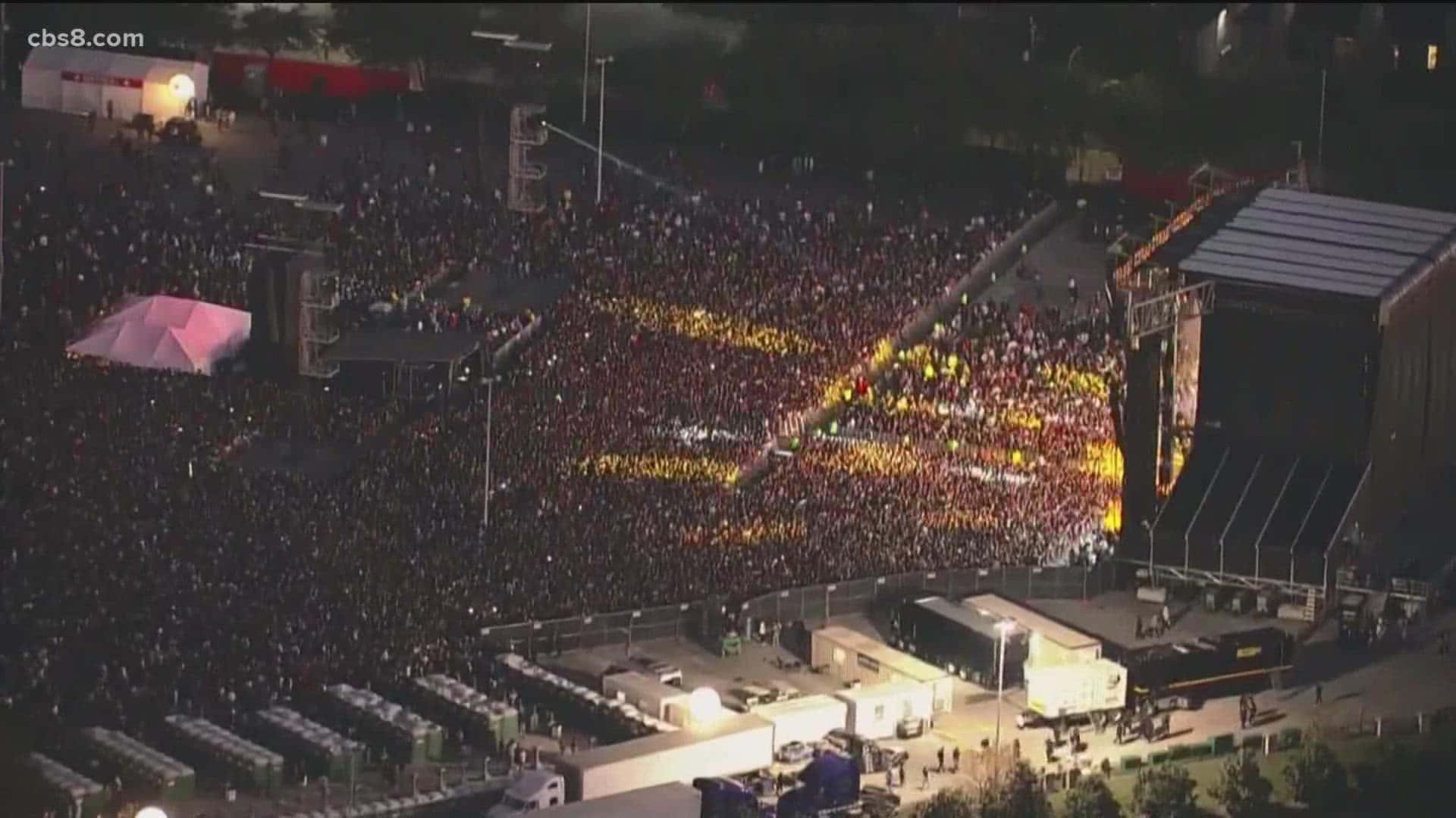 夜晚大型音樂會人群的鳥瞰圖，帶有照明舞台和發光的光圖案。