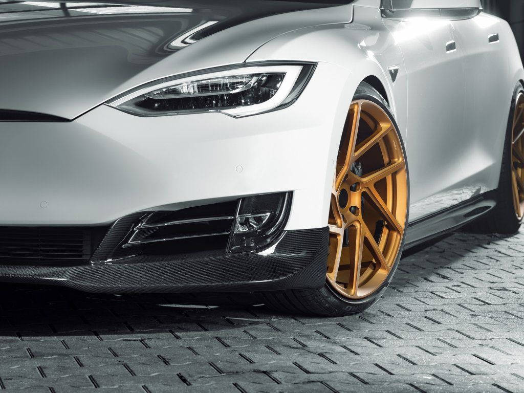 特斯拉Model S Novitec改裝版 壁紙 — 一輛時尚的白色Tesla，配金色輪圈，停在有紋理的灰色路面上，在明亮的攝影棚燈光下。