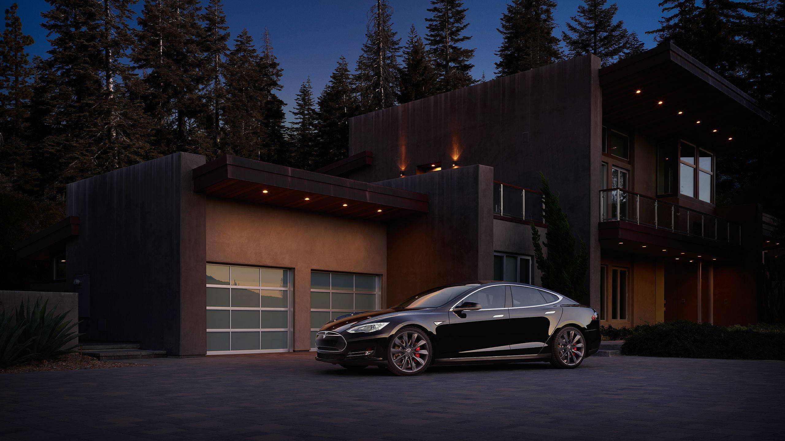 特斯拉Model S黑色 壁紙 — 一輛時尚的黑色Tesla房車停在一間現代木屋前，背景是黃昏時分的高大松樹。
