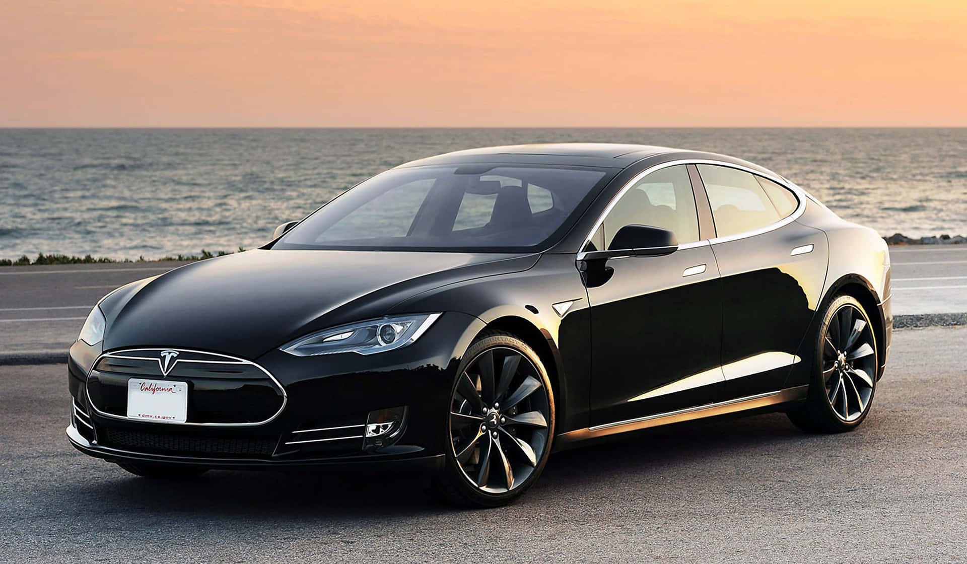 日落時分，黑色Tesla Model S停泊在海邊。