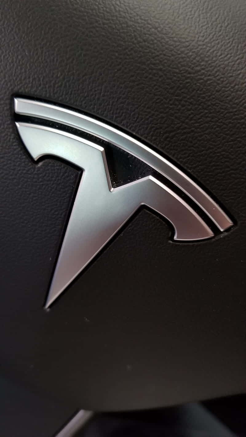 黑色皮革汽車內飾上的時尚銀色 Tesla 標誌。