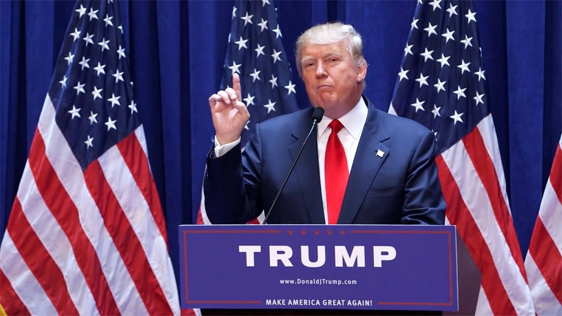 特朗普宣布2020總統參選 壁紙 — 當勞·特朗普站在一個藍色講台上，上面有「TRUMP」和「MAKE AMERICA GREAT AGAIN」字樣，他向上做手勢，兩旁有美國國旗。