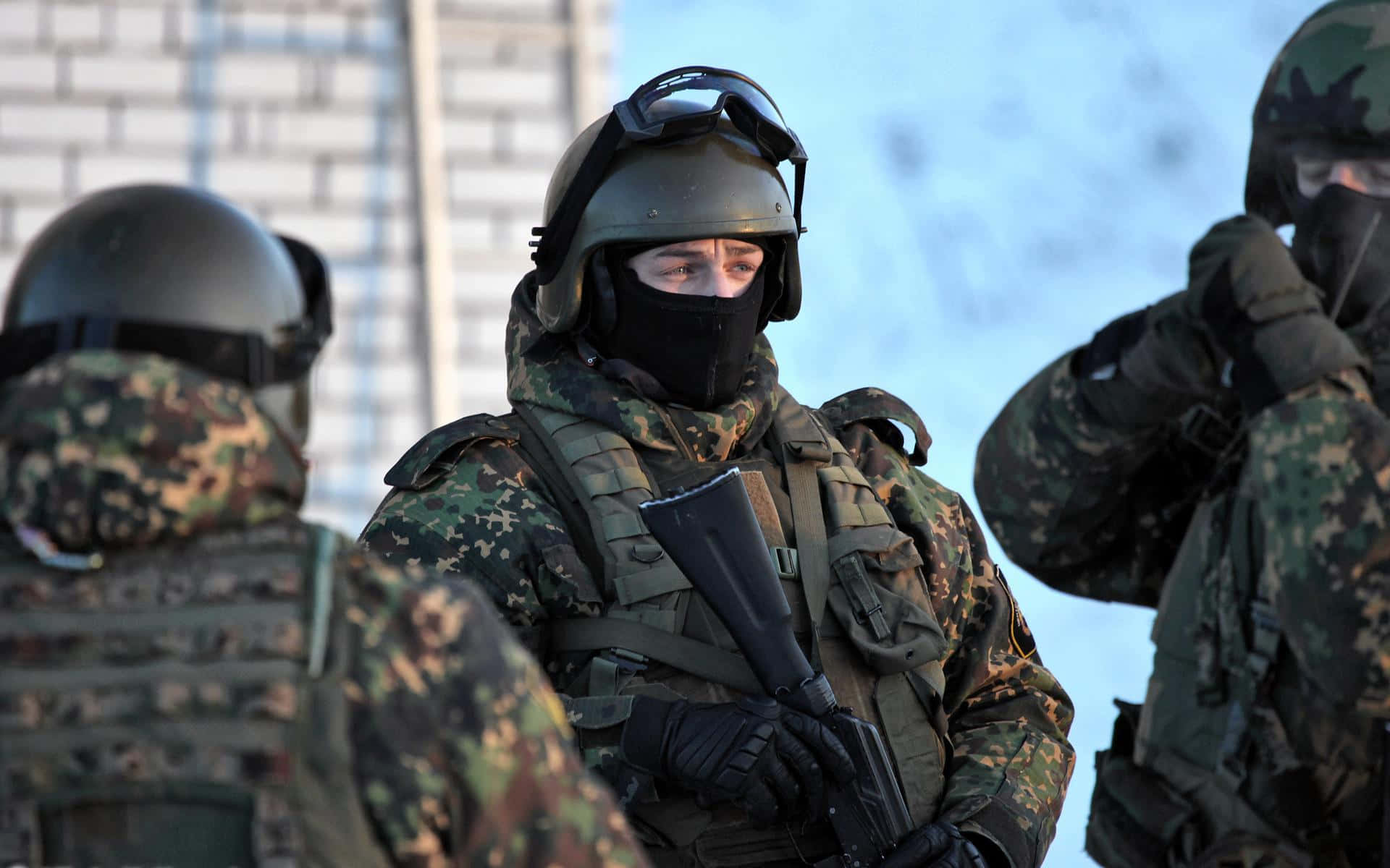三名穿著冬季迷彩裝備的士兵在雪地中戶外站立。
