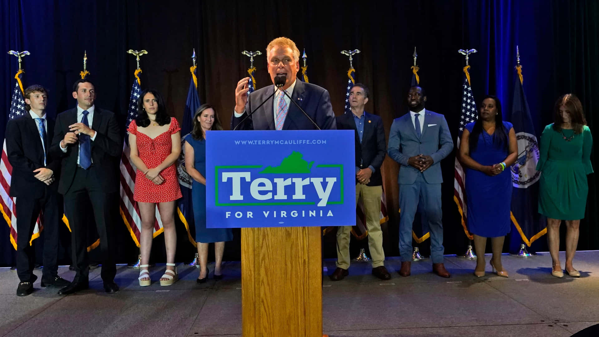 政治家 Terry McAuliffe 在競選活動中發言，身後有支持者。