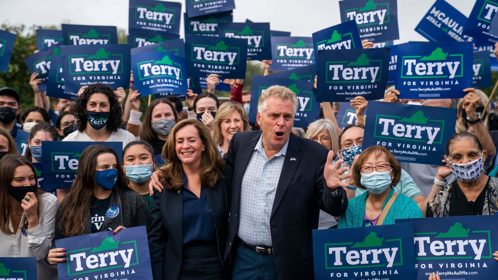 政治候選人Terry在維珍尼亞州的競選集會上，與舉著標語的支持者在一起。