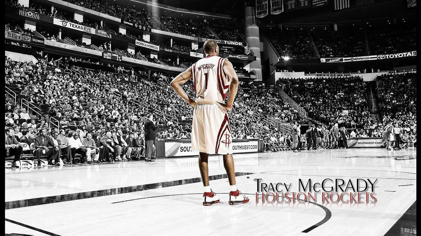 身穿侯斯頓火箭隊球衣的 Tracy McGrady 站在籃球場上，背景有觀眾。