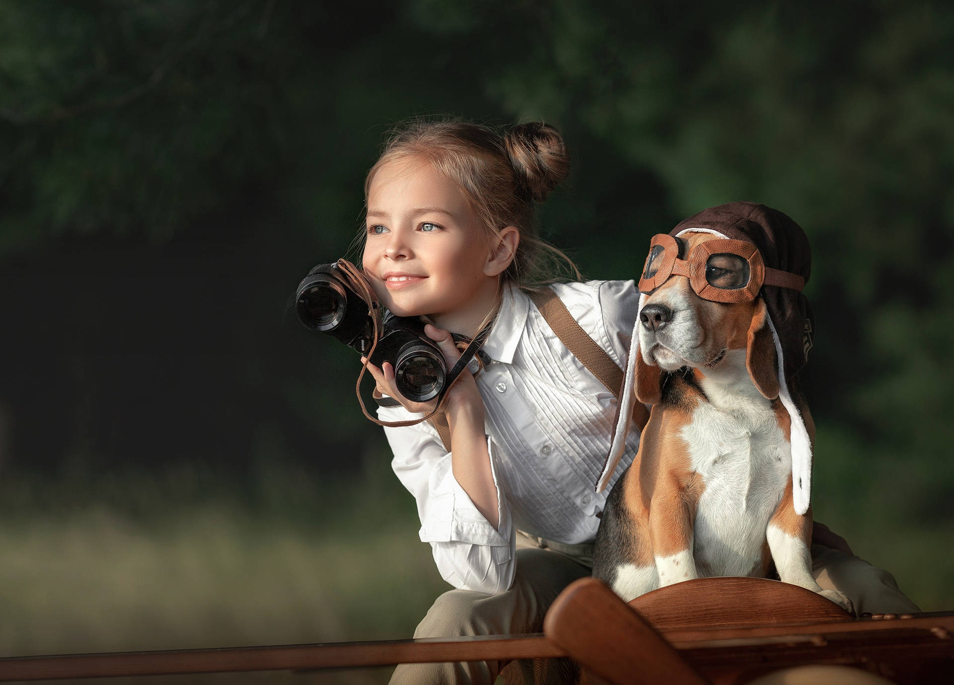 女孩和比格犬穿著飛行裝備從船上透過望遠鏡觀看。
