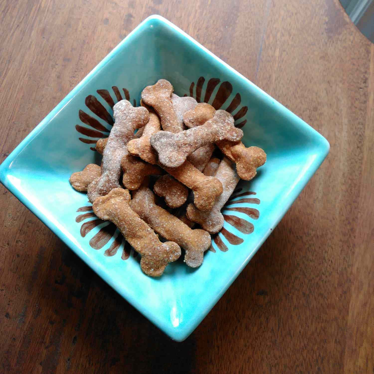 綠松石碗，木質表面上放有骨形狗零食。