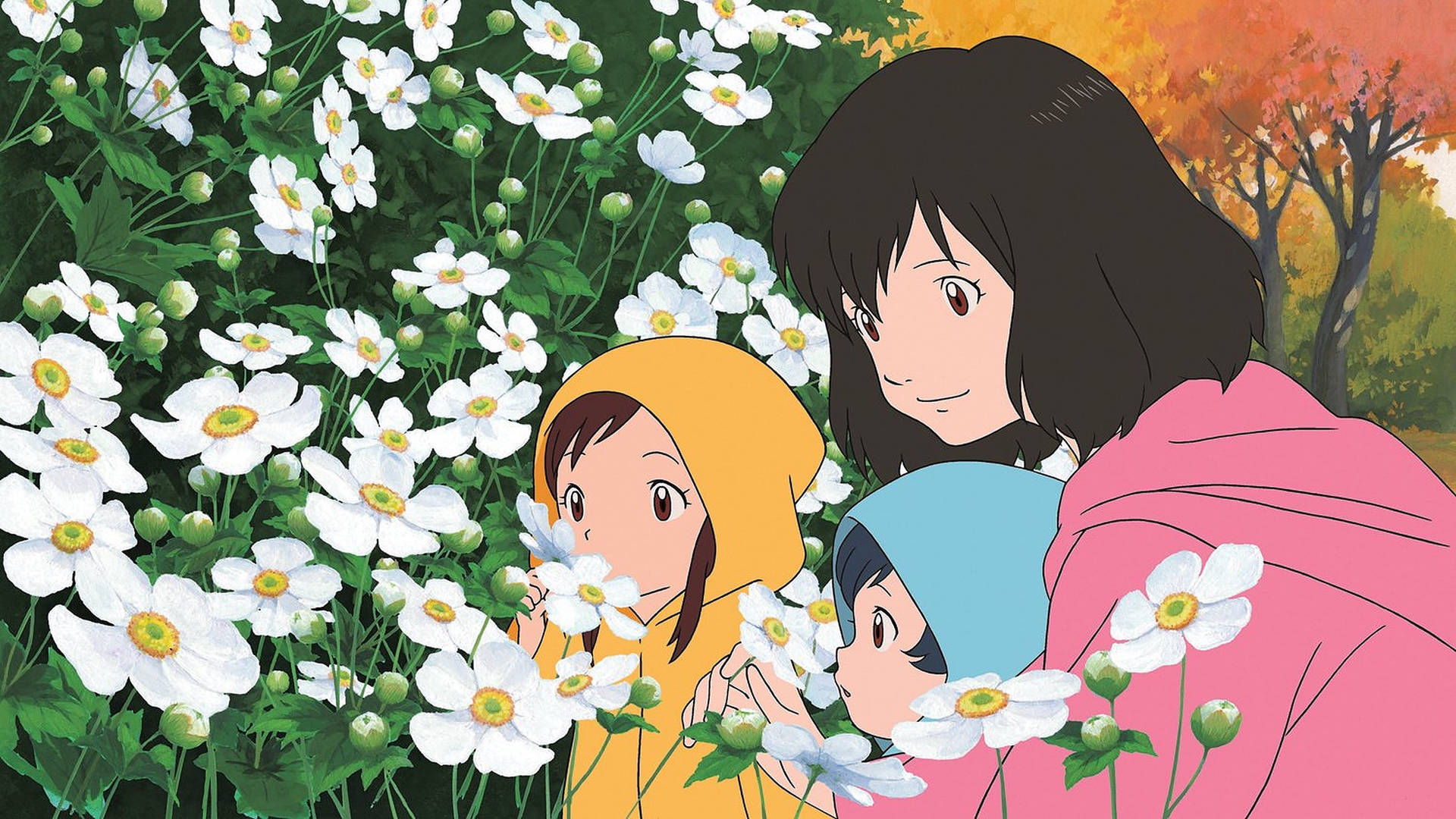 女士和兩個孩子穿著連帽衫在秋日花園中聞白色花朵