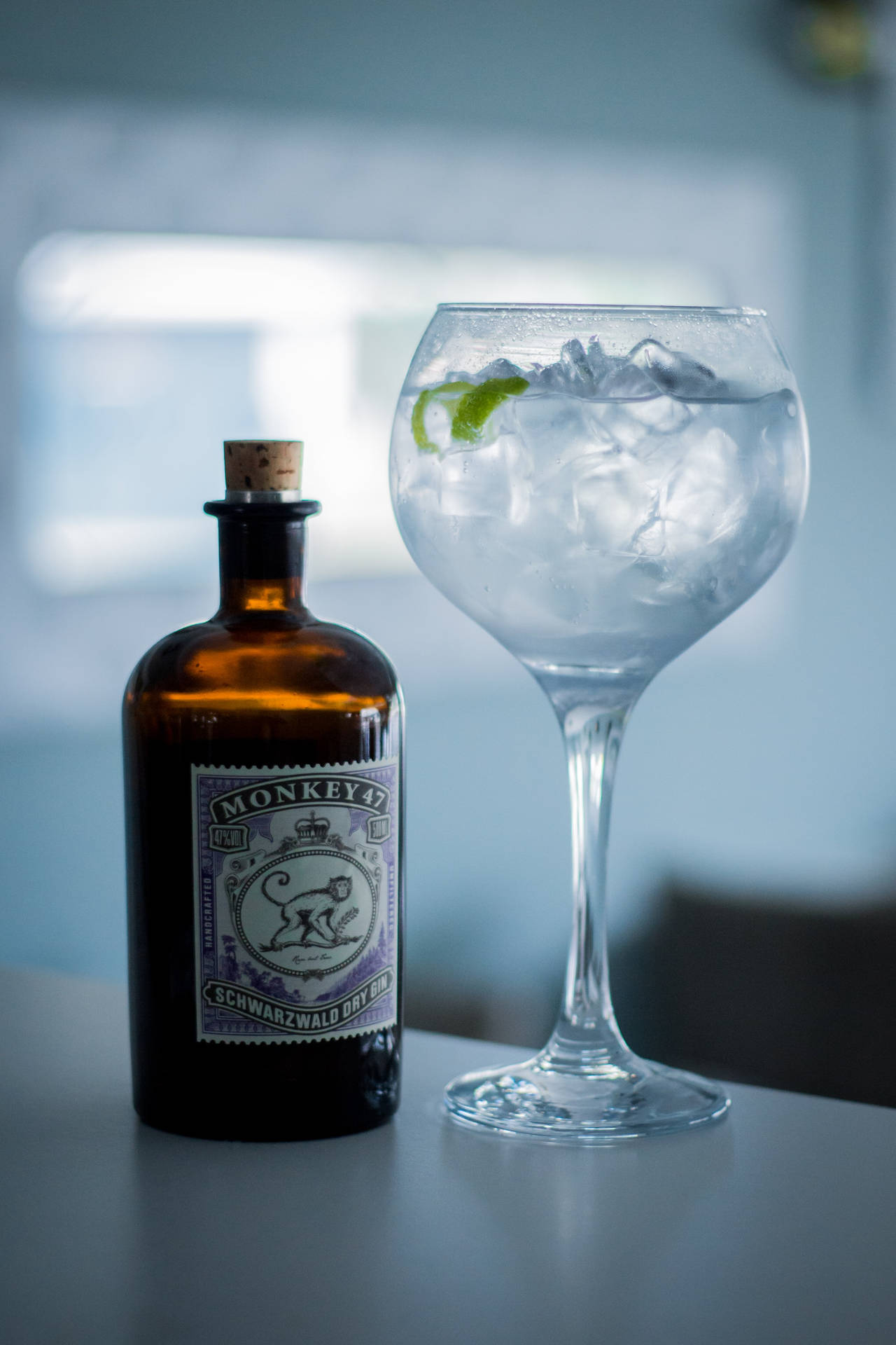 Monkey 47氈酒瓶和加冰及青檸的氈酒雞尾酒在櫃檯上。