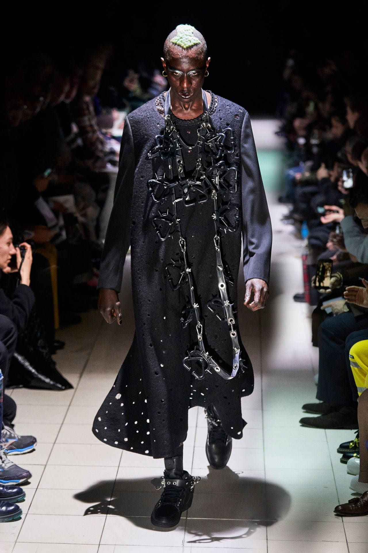 獨家Comme Des Garçons鏈條外套高解析度圖 壁紙 — 一位綠髮模特兒穿著飾有鏈條和星形金屬片的深色紋理外套走秀。