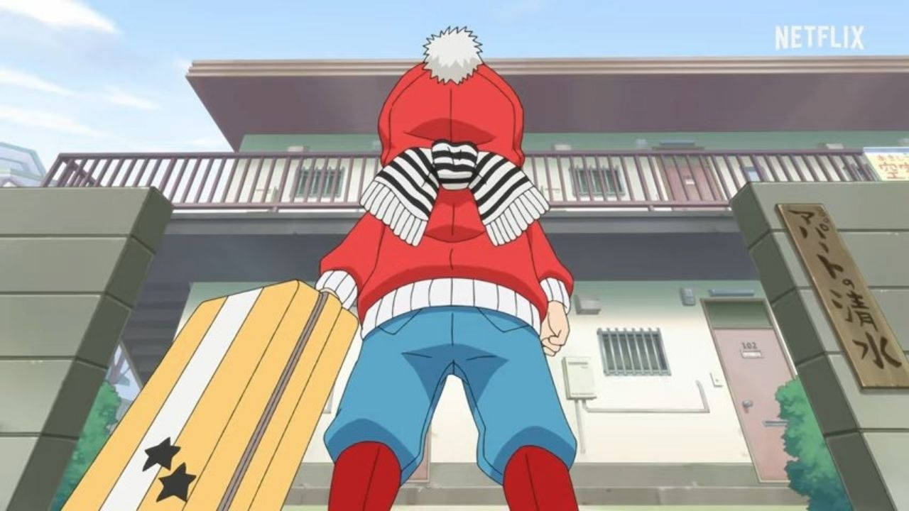 穿紅色連帽衫的小孩在大廈門口拿著衝浪板