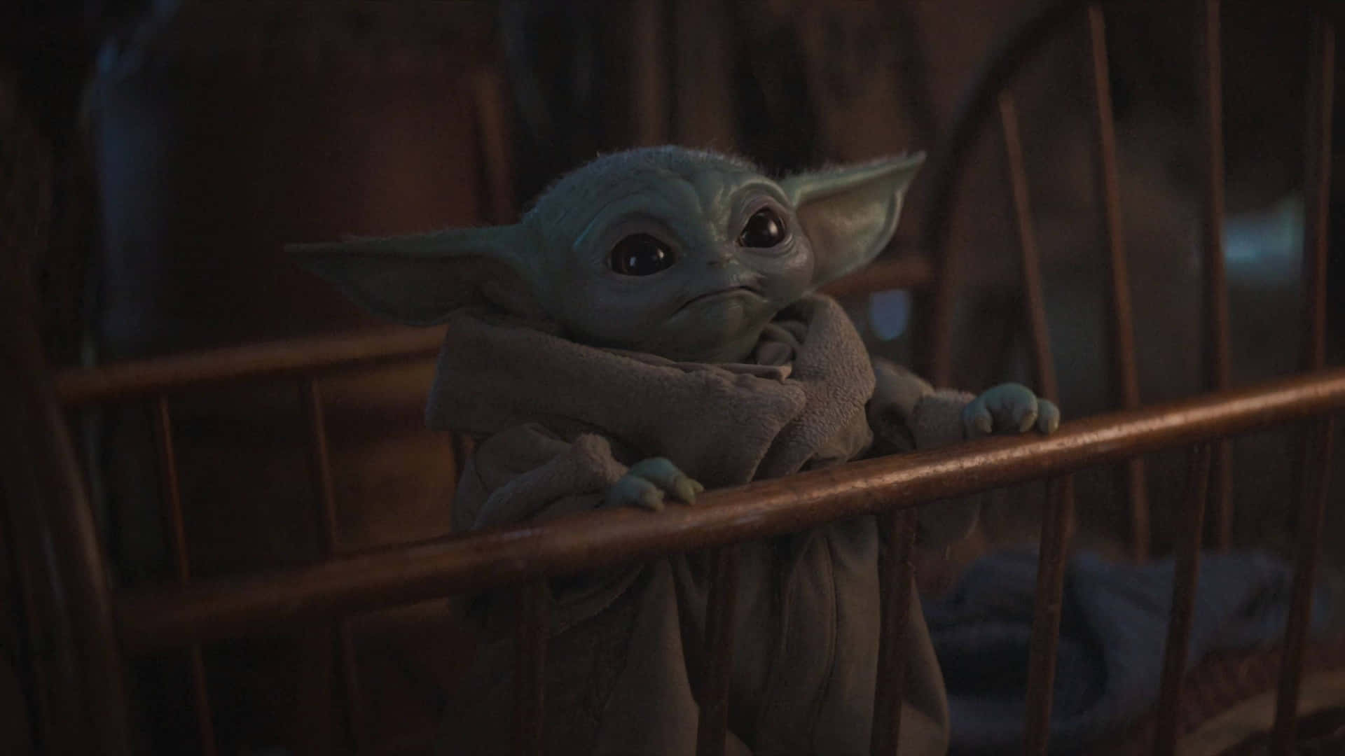 Baby Yoda 喺黑暗嘅房間入面喺木製嬰兒床欄杆上面偷睇。