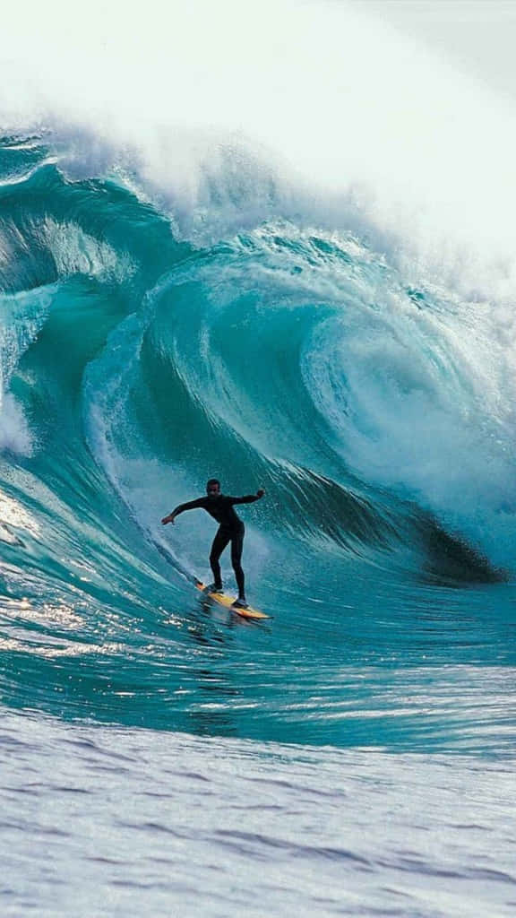 衝浪者在明亮的藍色海水中騎乘一道巨大的捲浪。