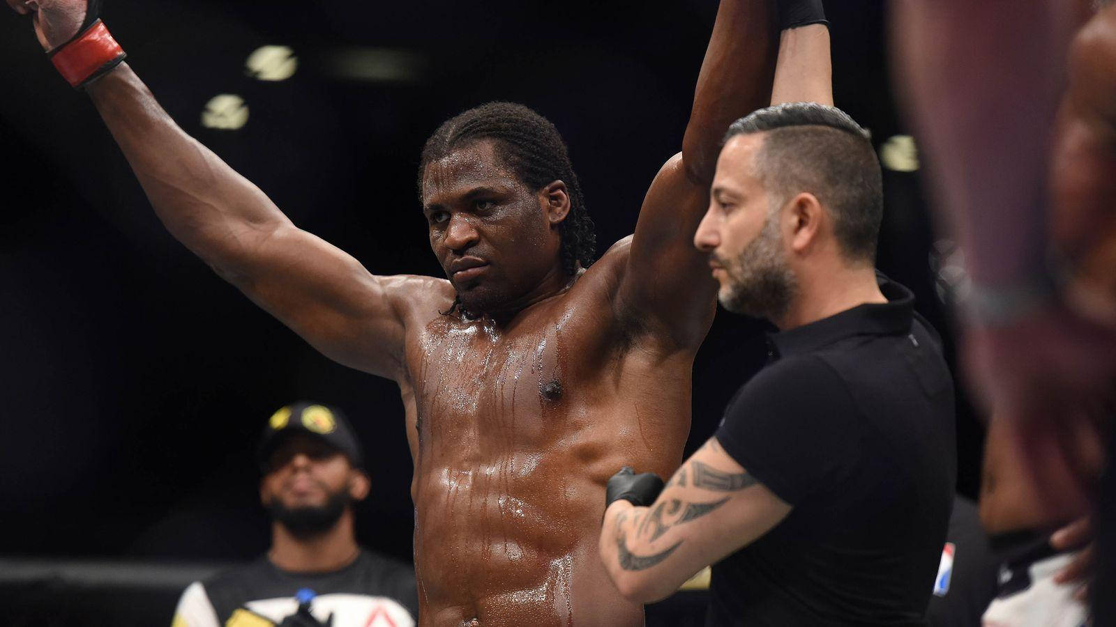 MMA拳手在八角籠內獲勝，裁判舉起他的手。