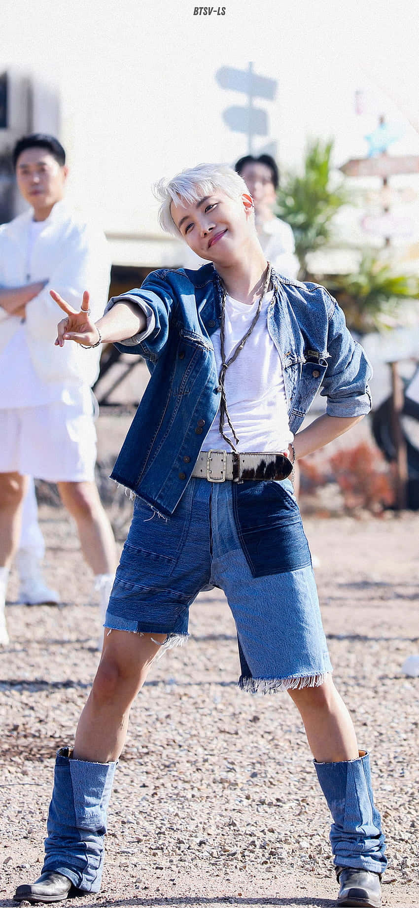 穿著牛仔服的年輕男子在戶外比出和平手勢