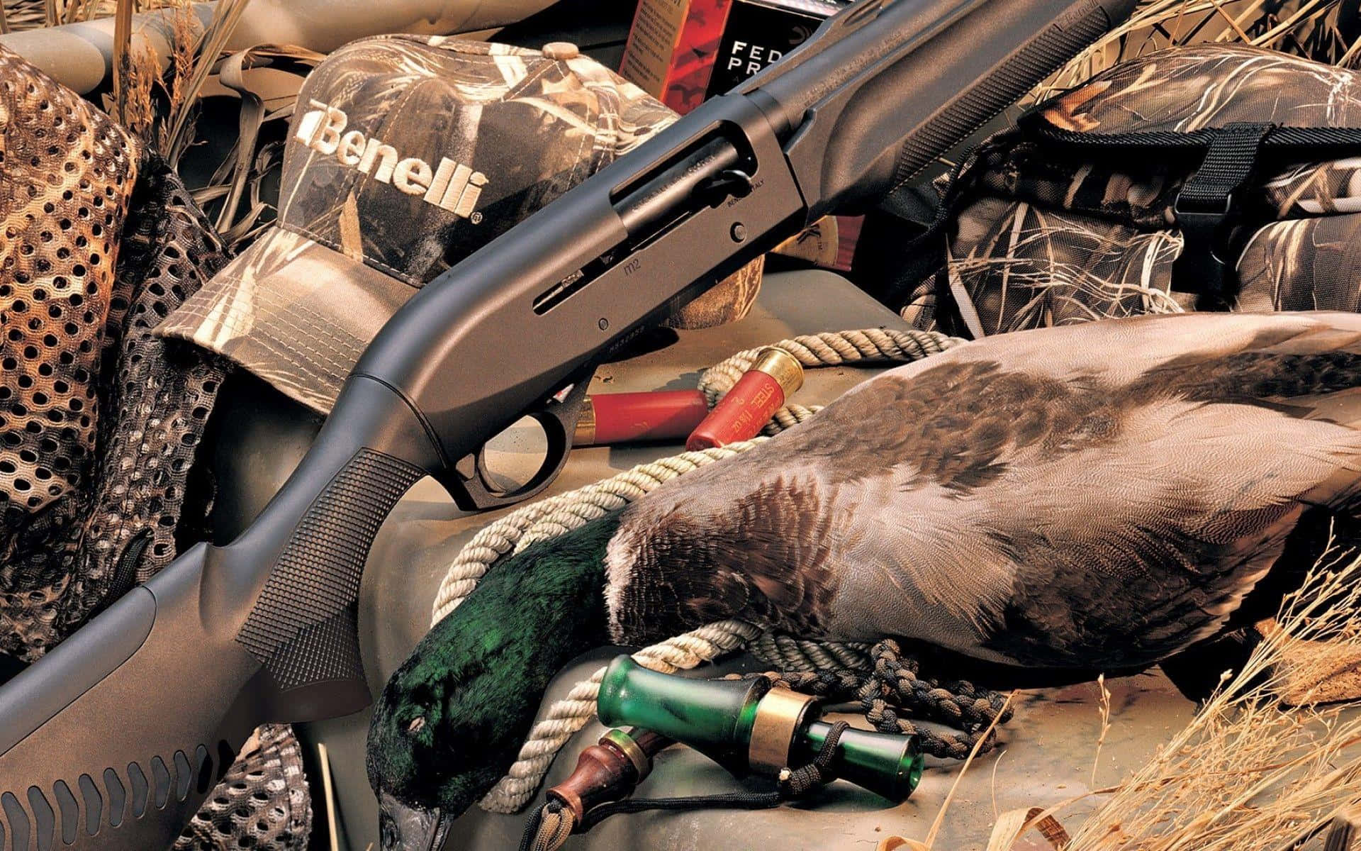獵人步槍與鳥類 壁紙 — 一隻收穫的鴨子躺在一把 Benelli 霰彈槍和狩獵裝備旁邊，表面覆蓋著迷彩。