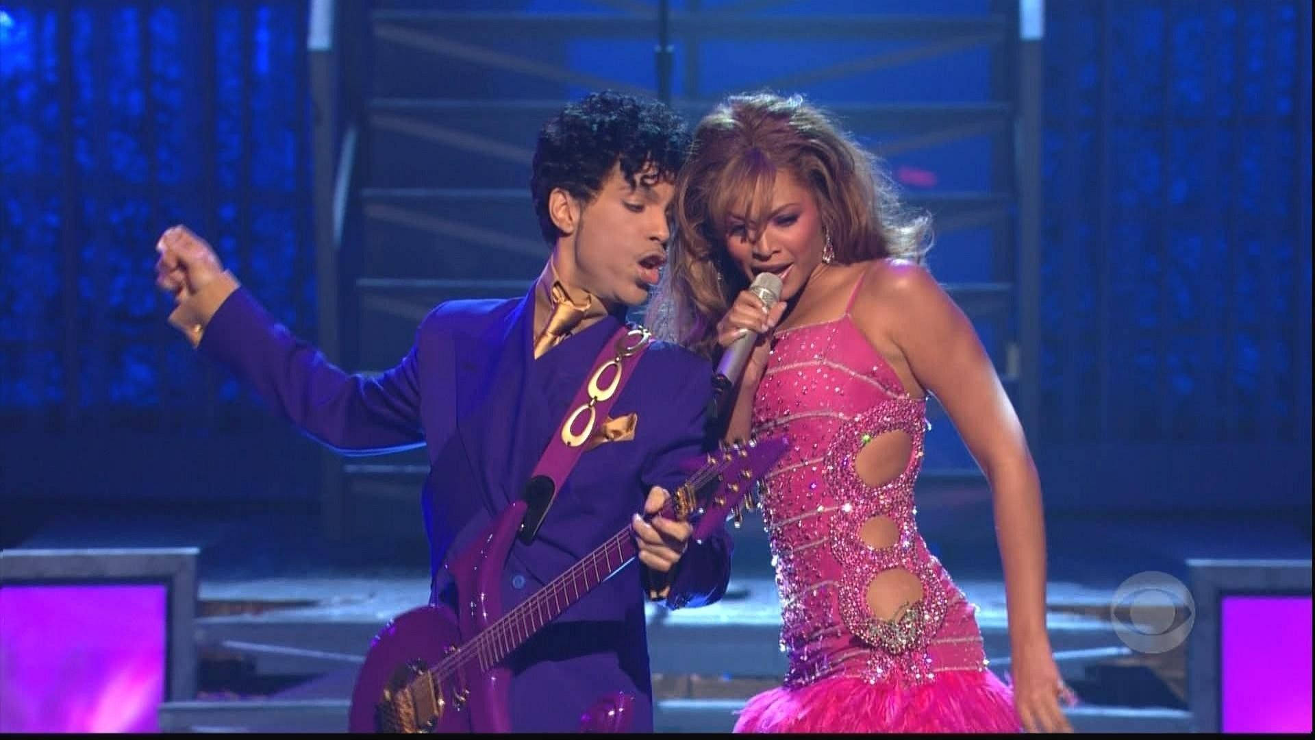 Prince和Beyoncé在藍色燈光下拿著結他和麥克風在舞台上表演。